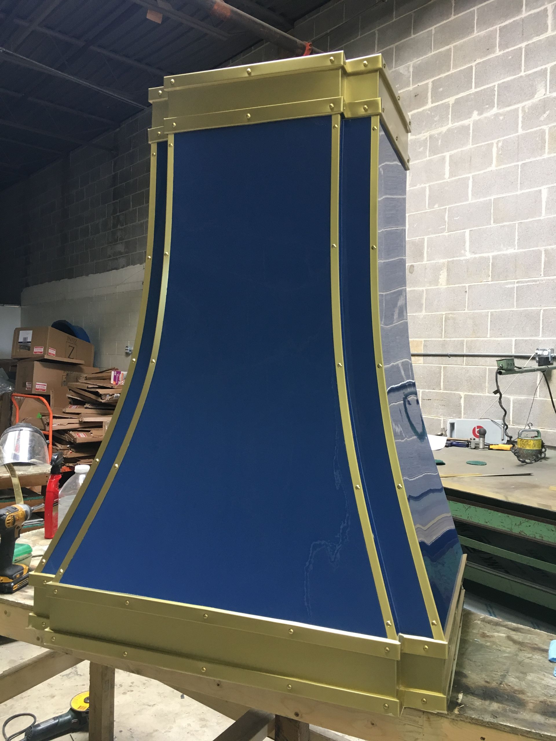 A blue and gold lamp shade is sitting on a wooden table