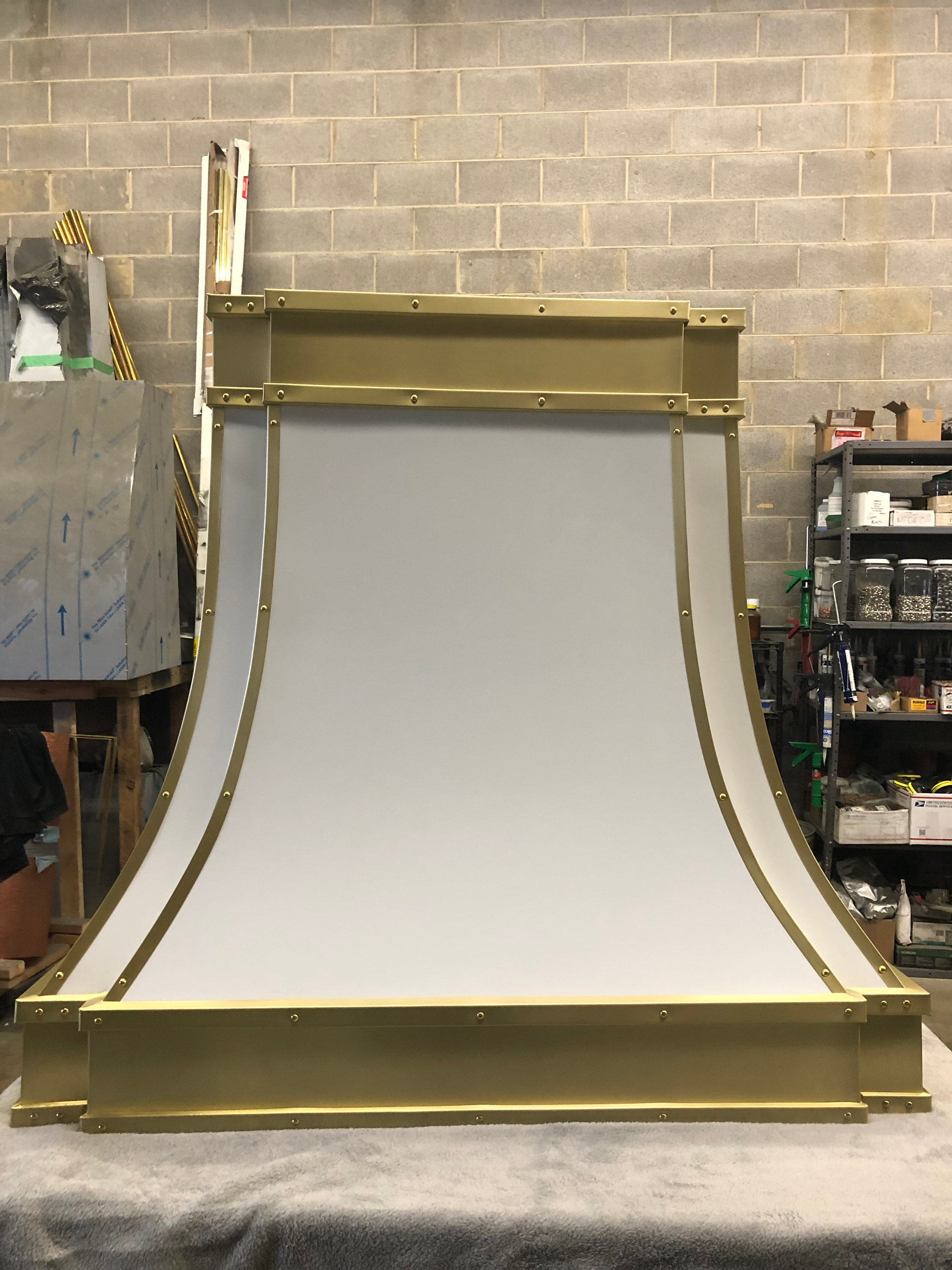 A white and gold object is sitting on a table in front of a brick wall