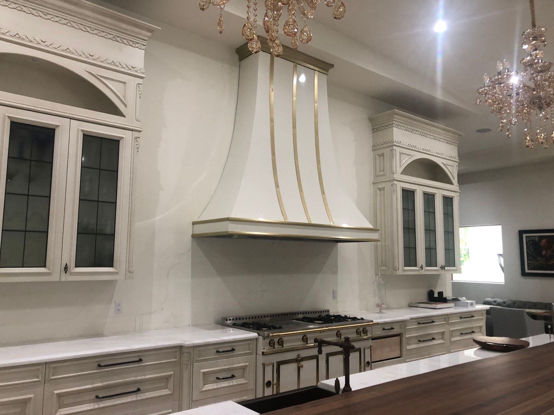 A kitchen with white cabinets and a stove top oven.