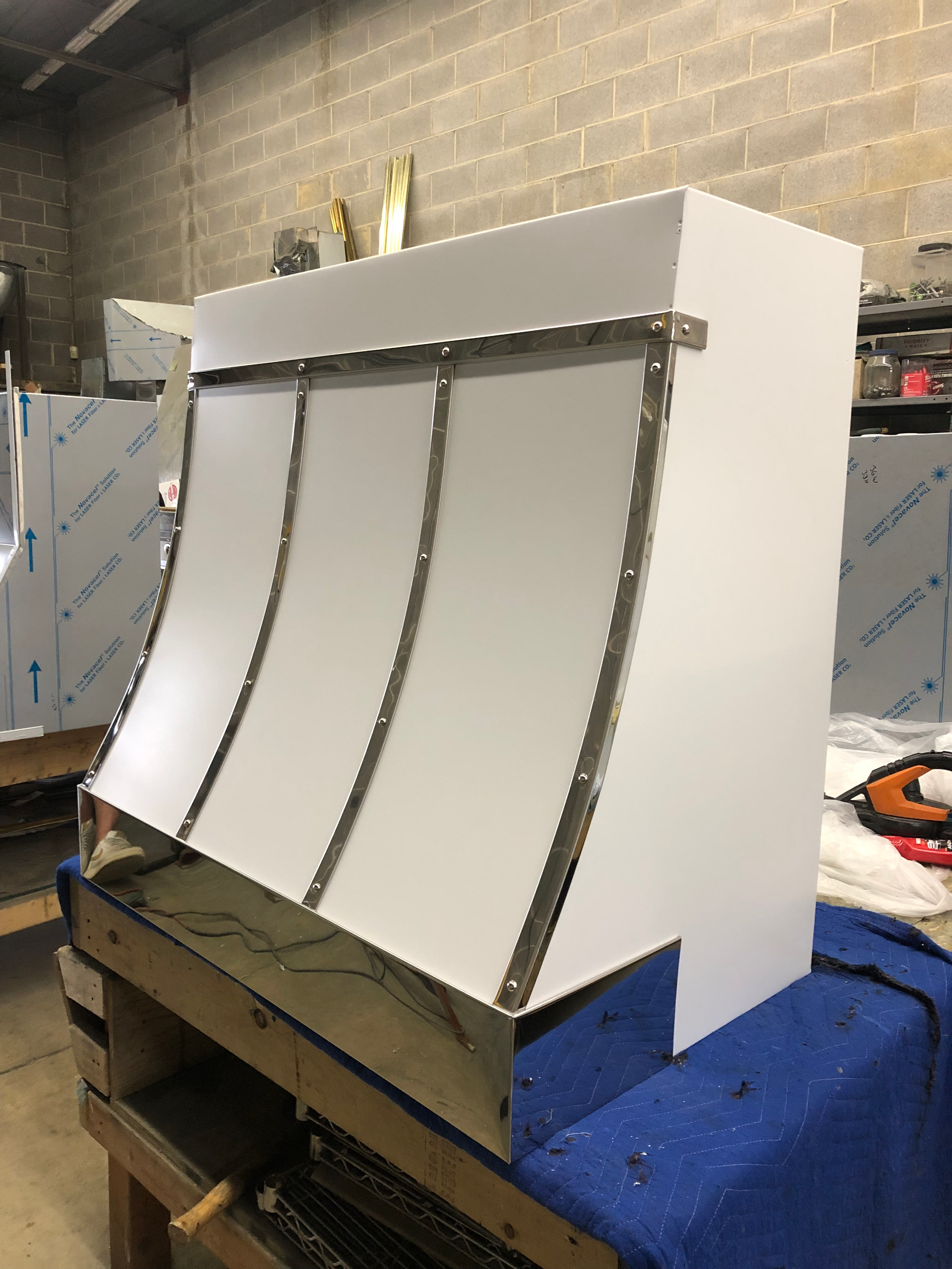 A stainless steel hood is sitting on top of a wooden table.