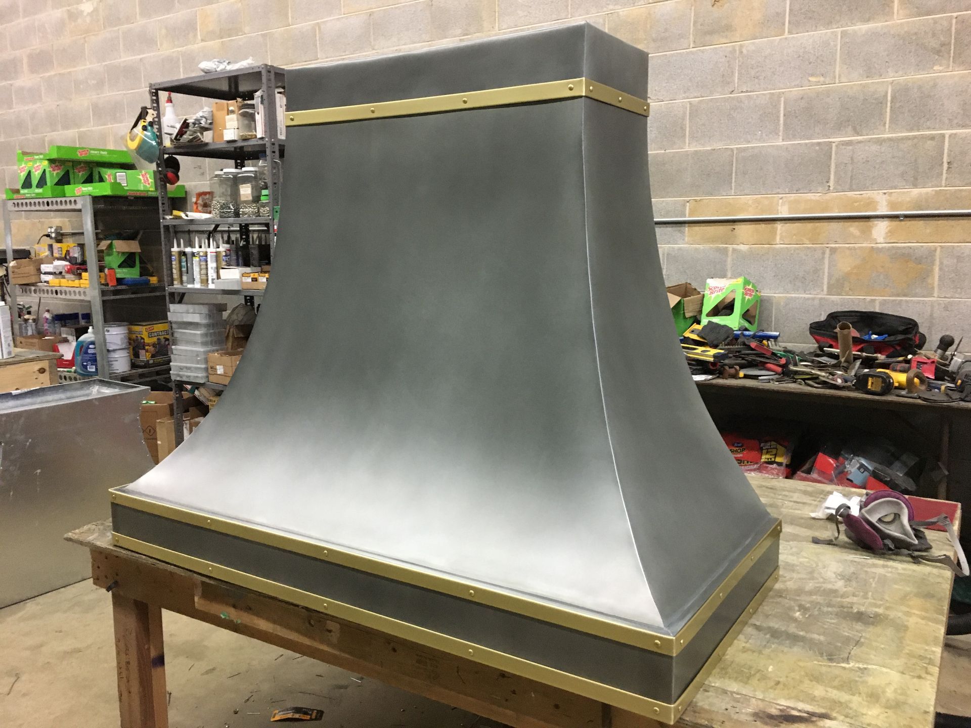 A metal hood is sitting on top of a wooden table.