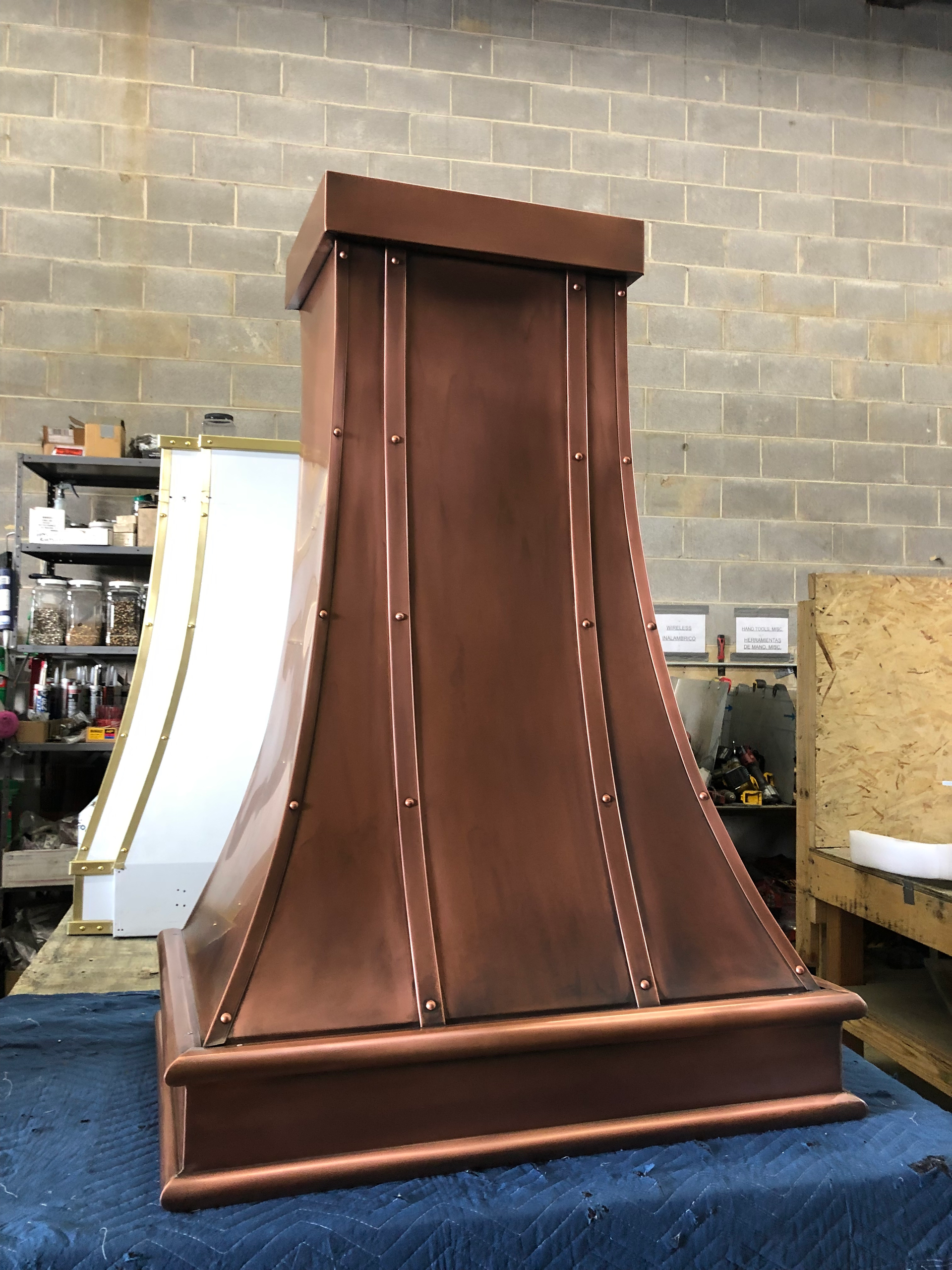 A copper hood is sitting on top of a blue table.