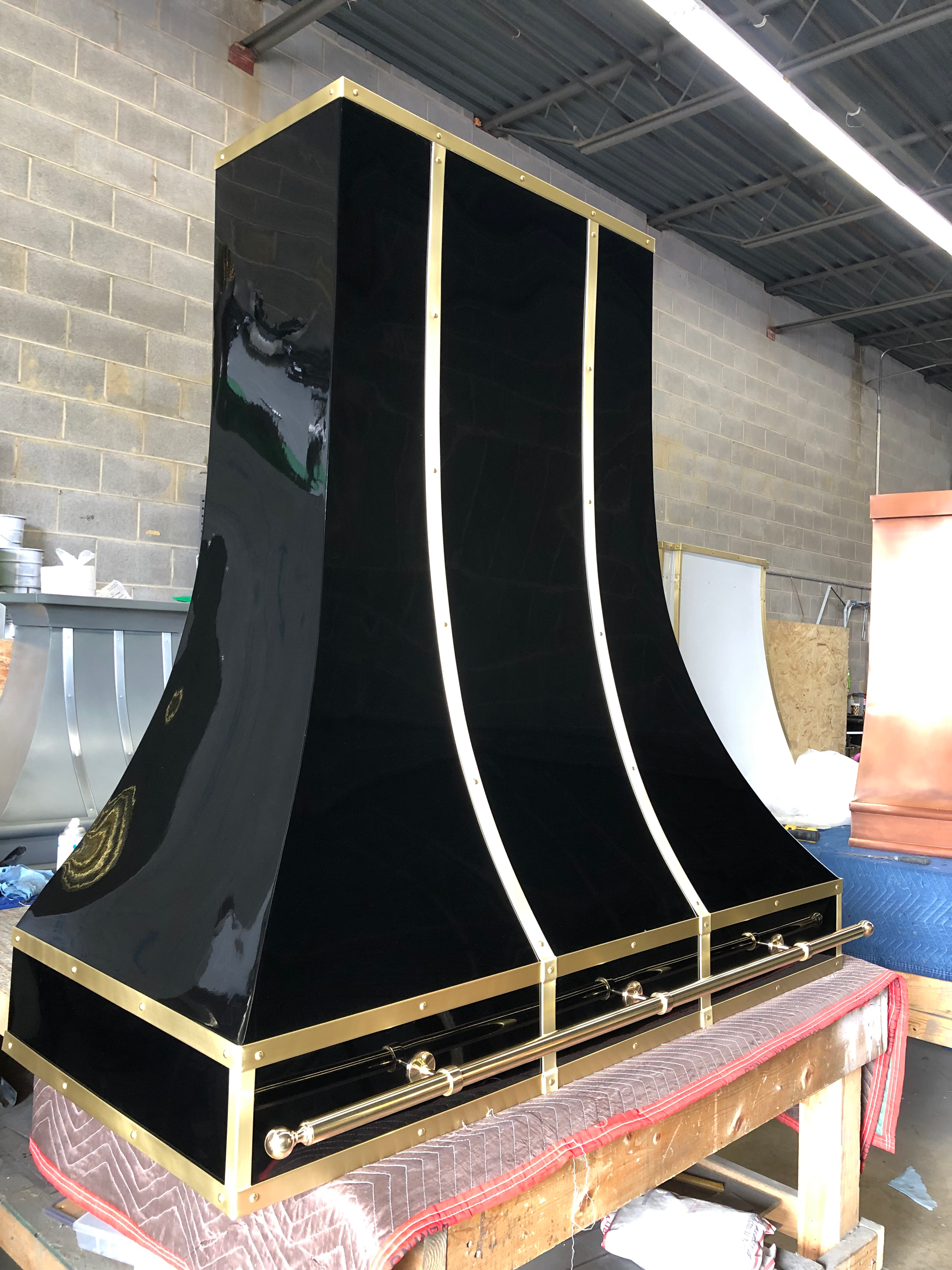 A black and gold hood is sitting on top of a wooden table.