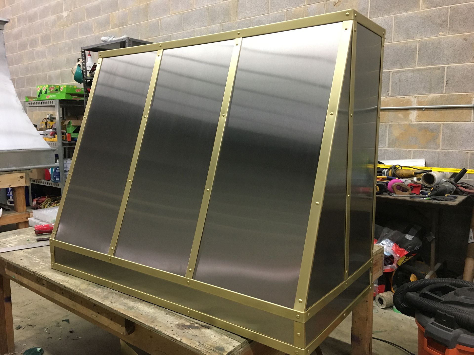 A stainless steel hood is sitting on a wooden table.