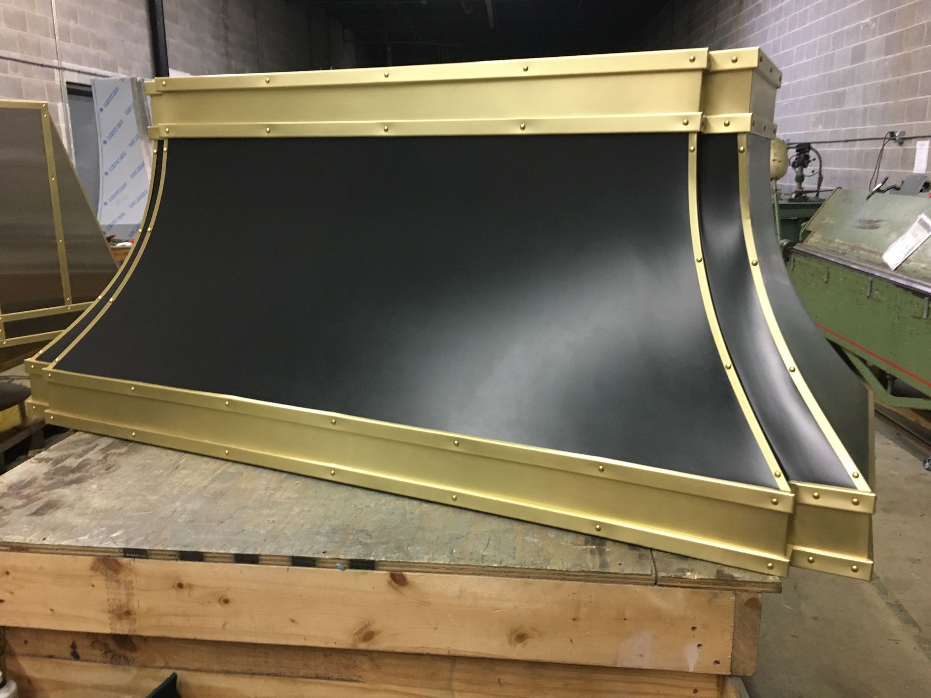 A black and gold object is sitting on a wooden pallet