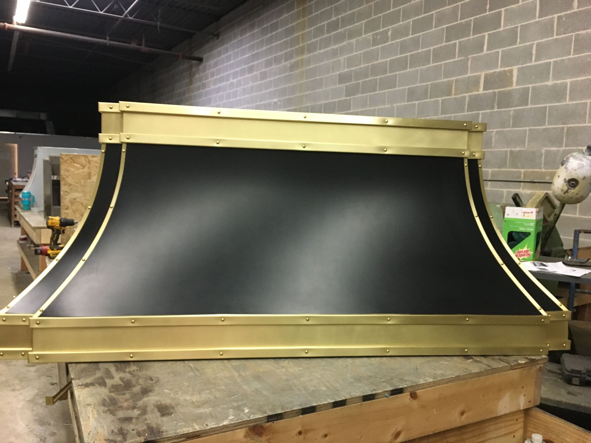 A black and gold hood is sitting on top of a wooden box.