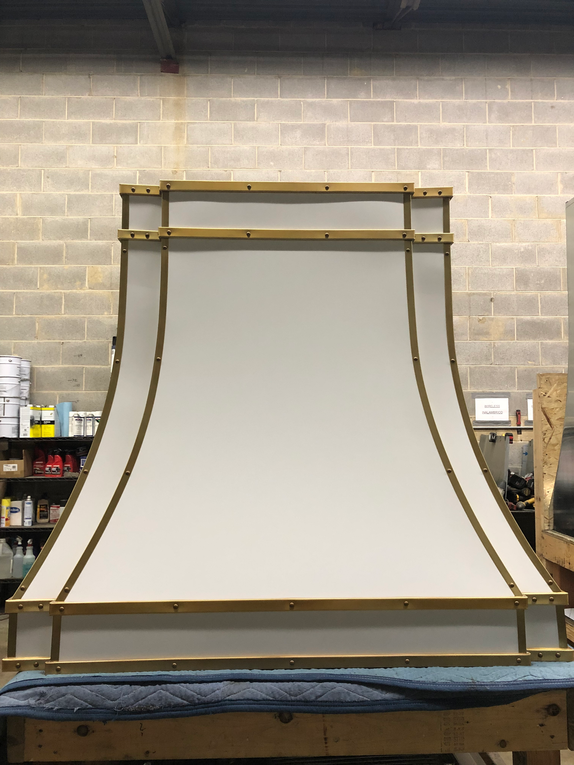 A white hood is sitting on a wooden table in front of a brick wall.