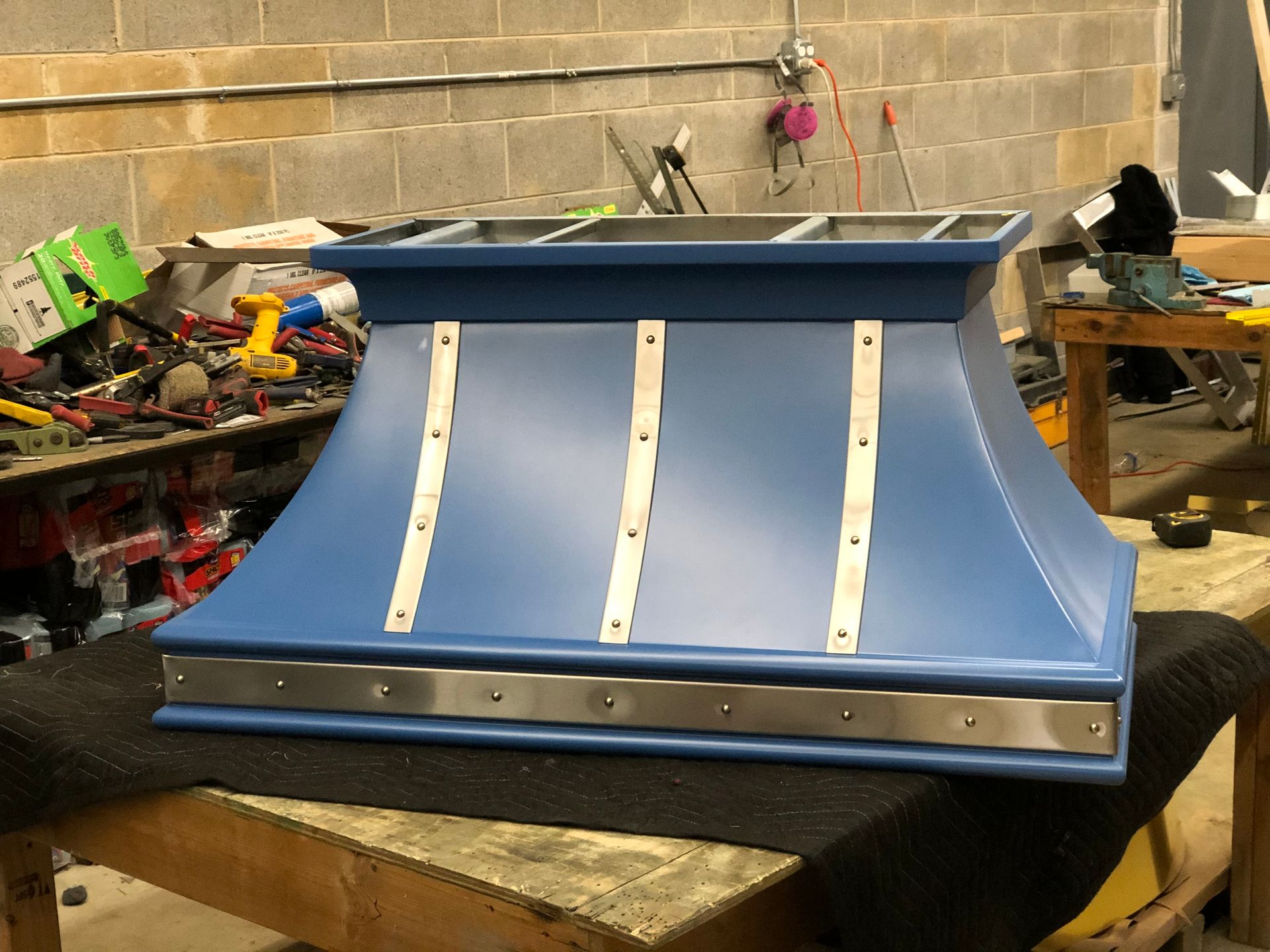 A blue hood is sitting on top of a wooden table.