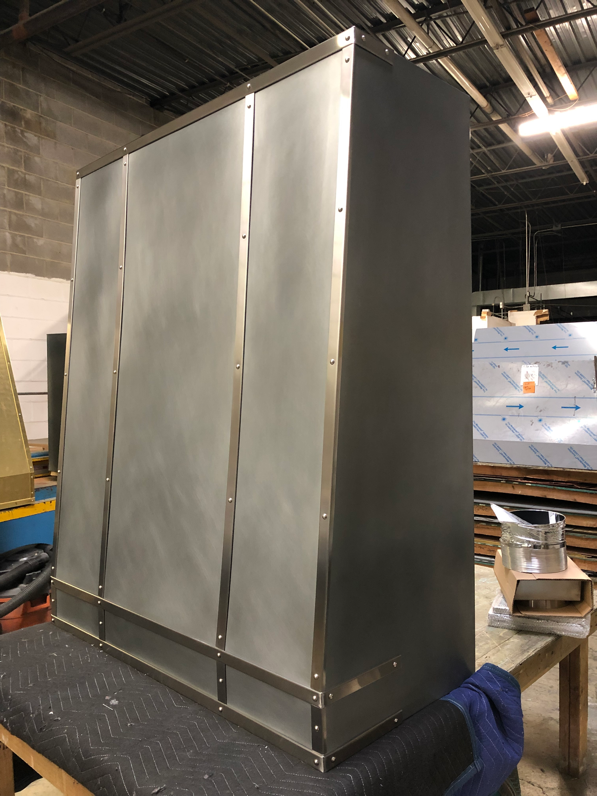A stainless steel cabinet is sitting on a table in a warehouse