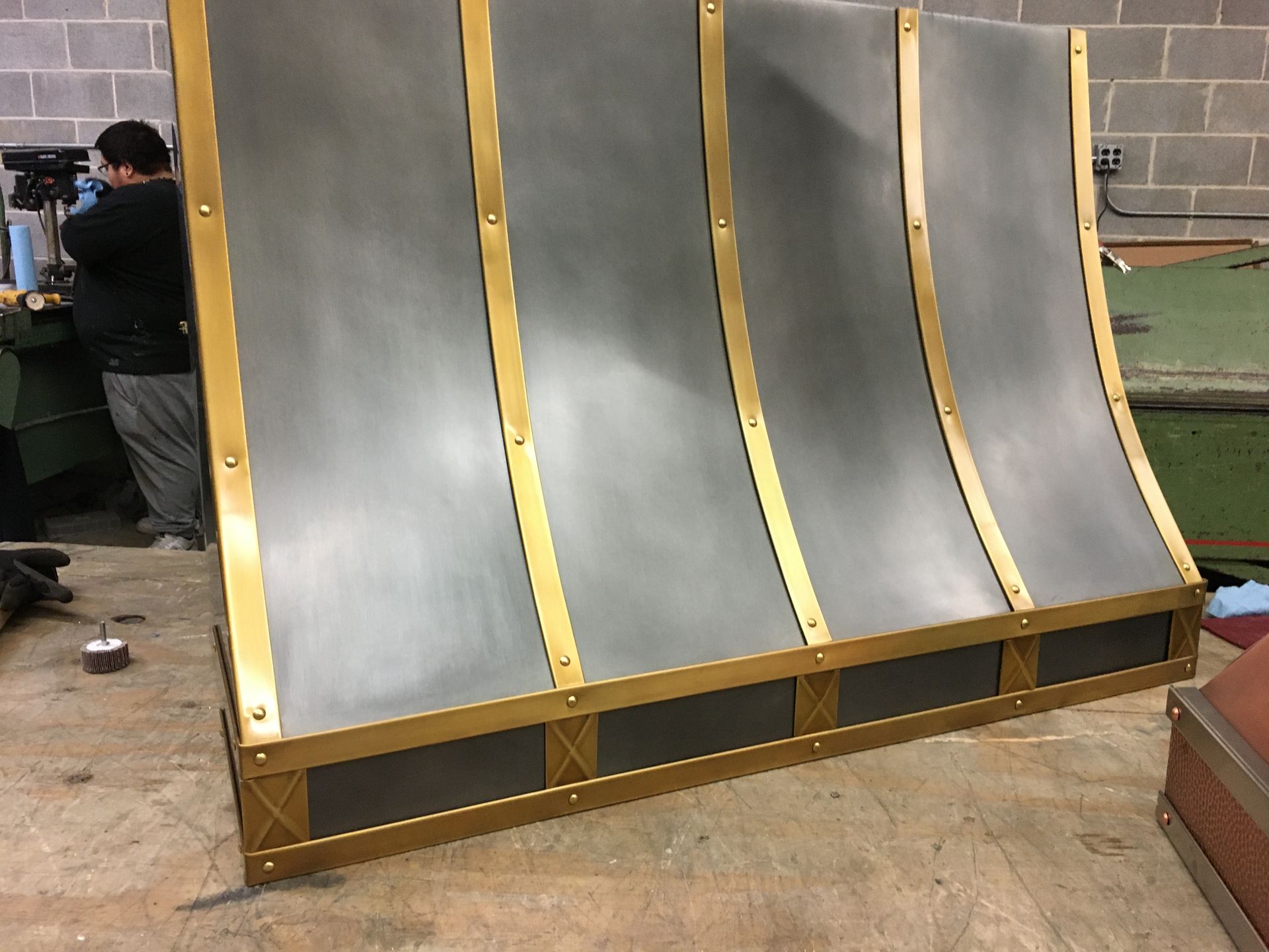 A man is working on a piece of metal on a table.