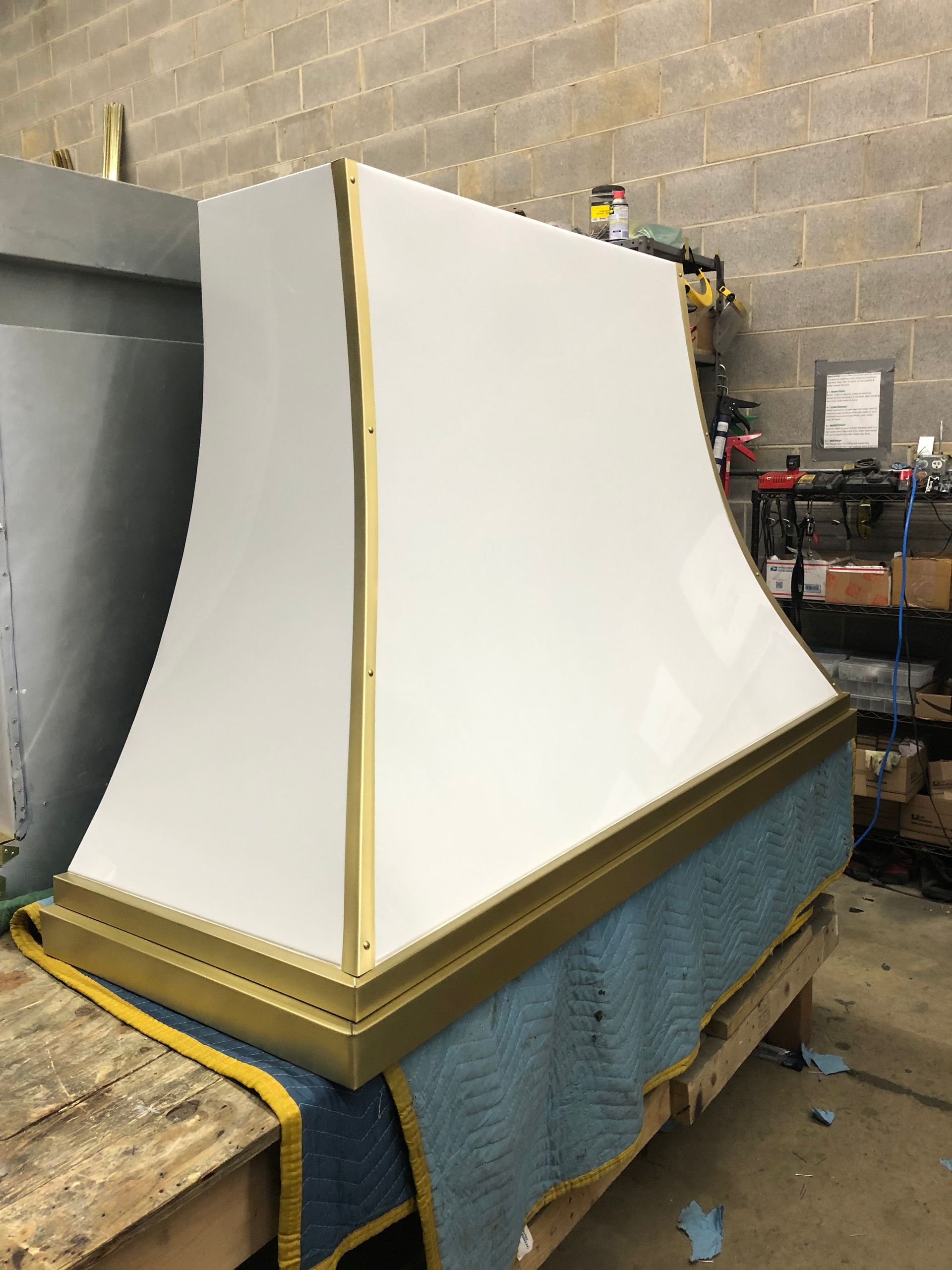 A white and gold hood is sitting on top of a wooden table.