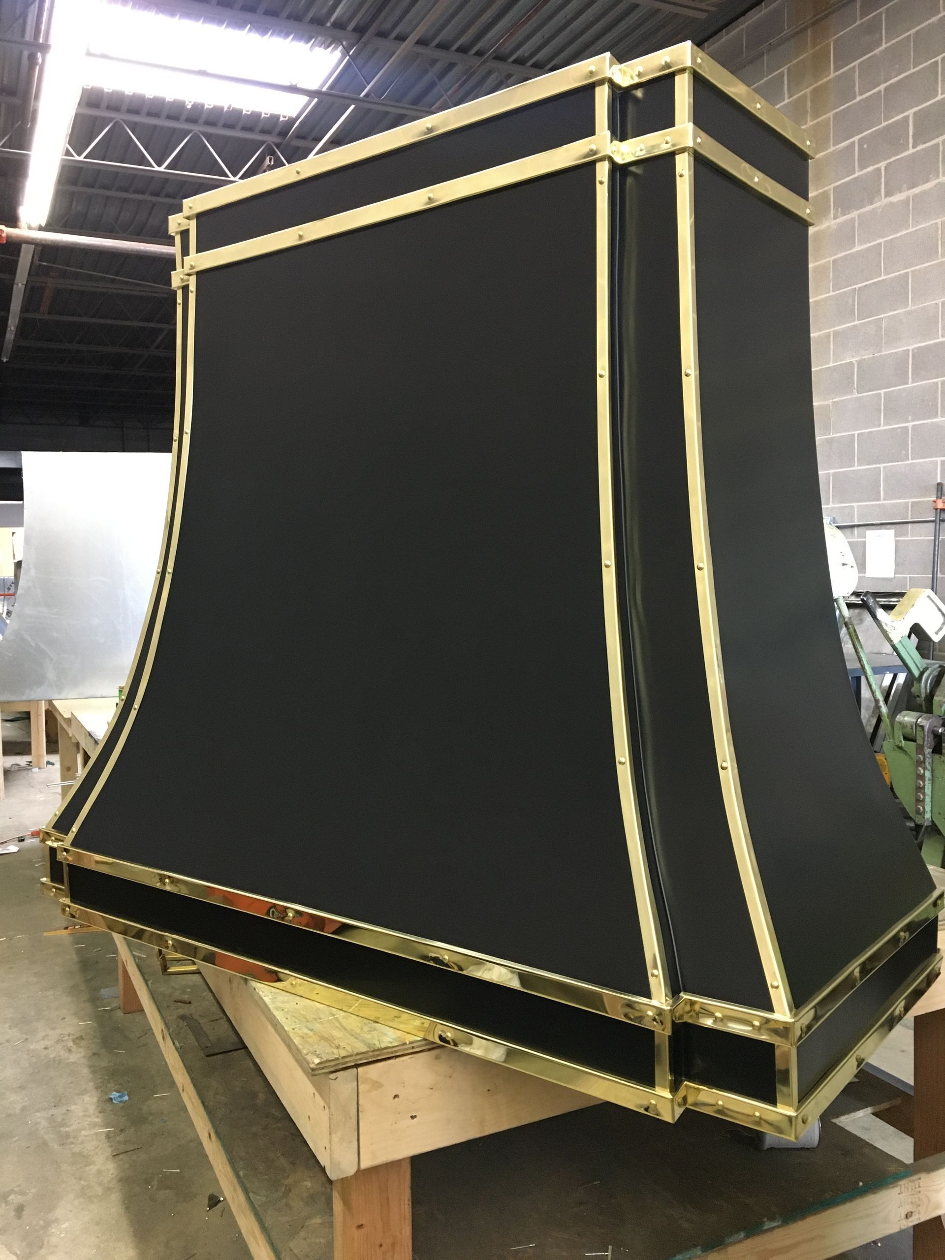 A black and gold hood is sitting on a wooden table