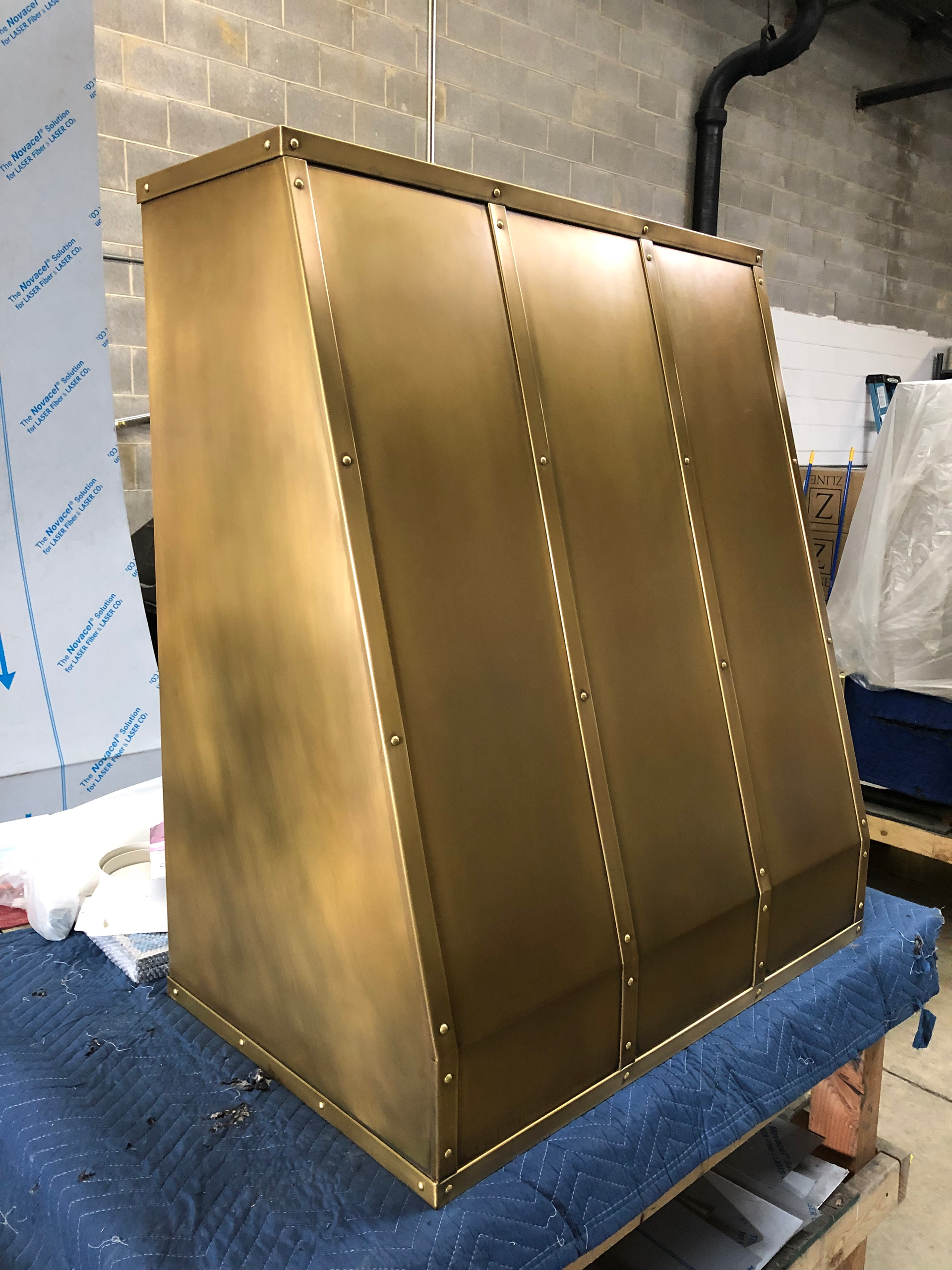 A brass cabinet is sitting on top of a blue table.