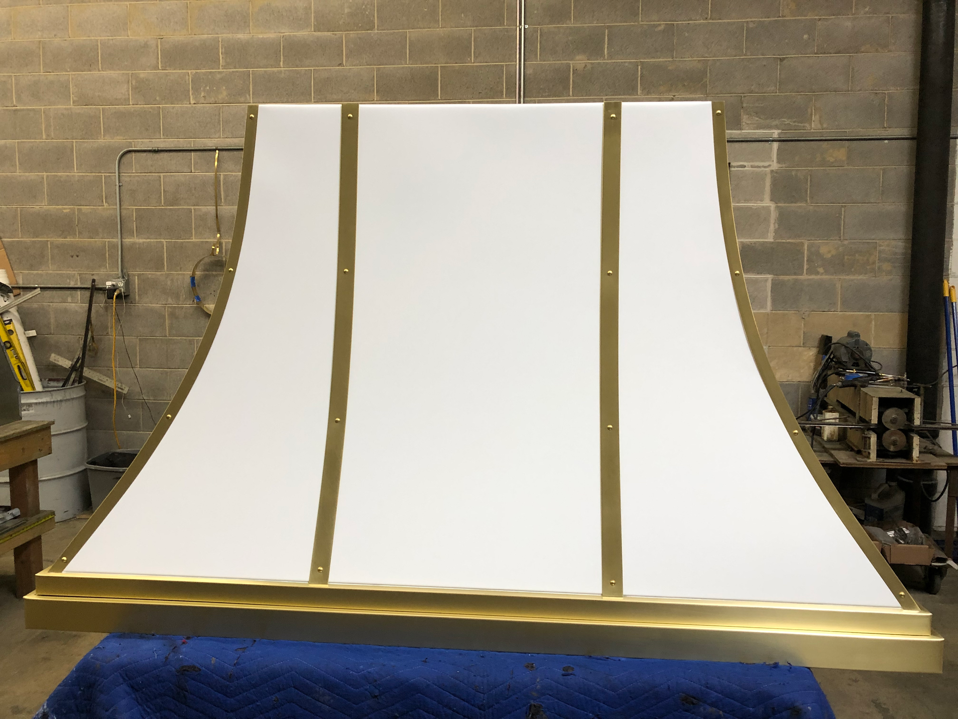 A white and gold hood is sitting on a blue table.