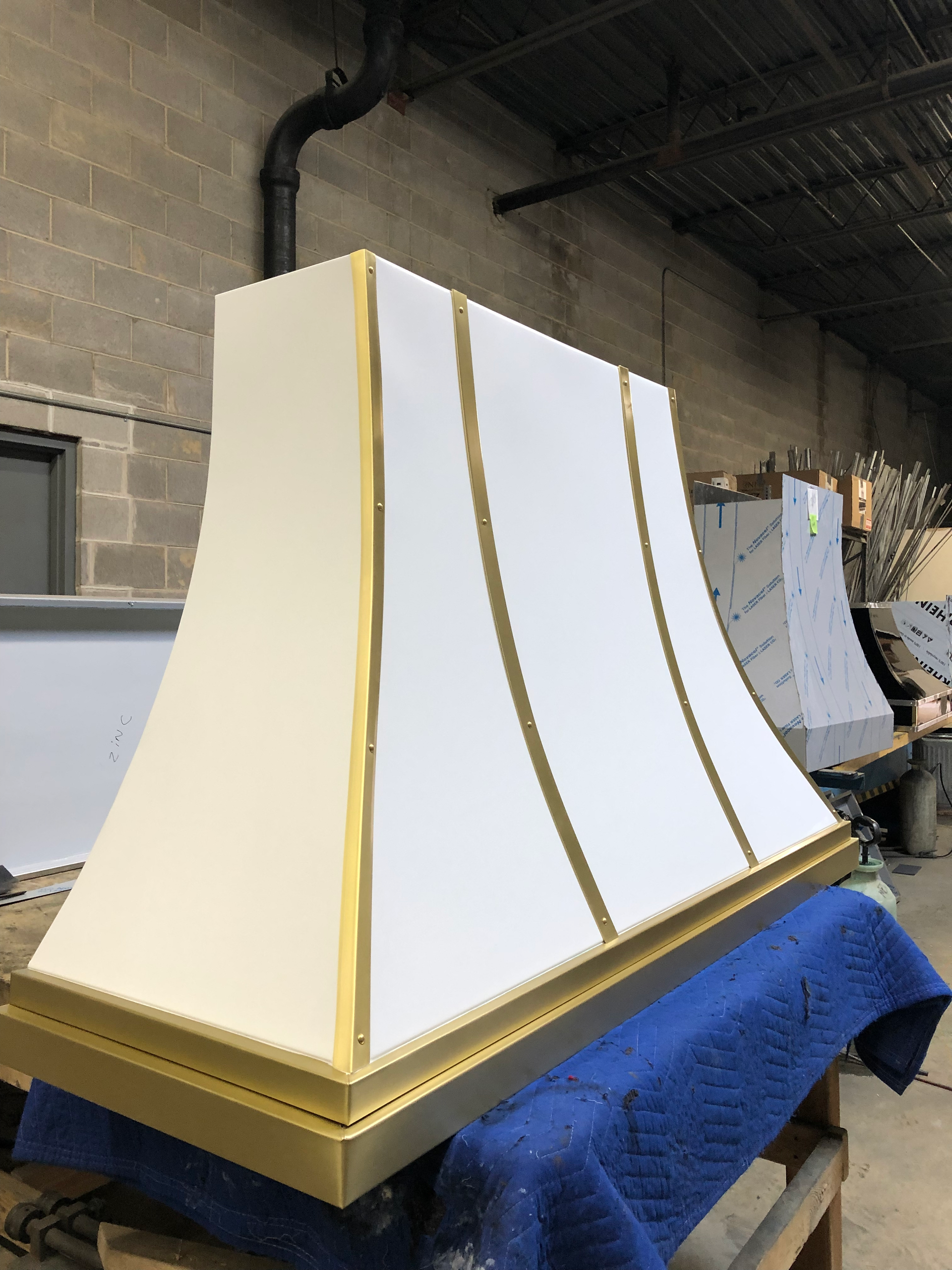 A white and gold hood is sitting on top of a blue table.