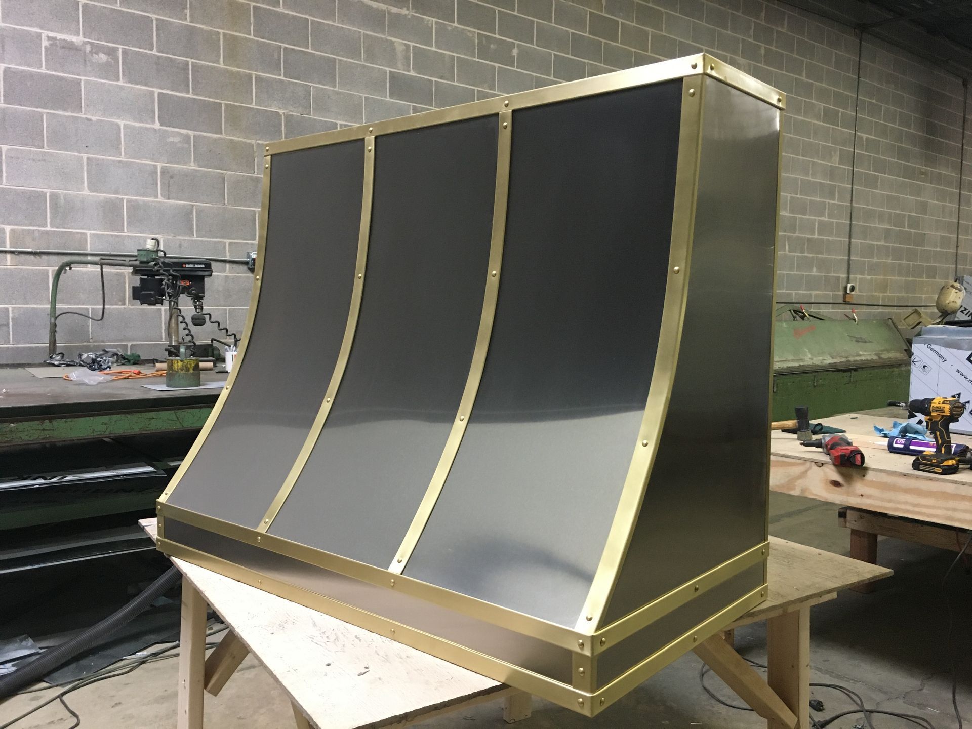 A stainless steel hood is sitting on top of a wooden table.