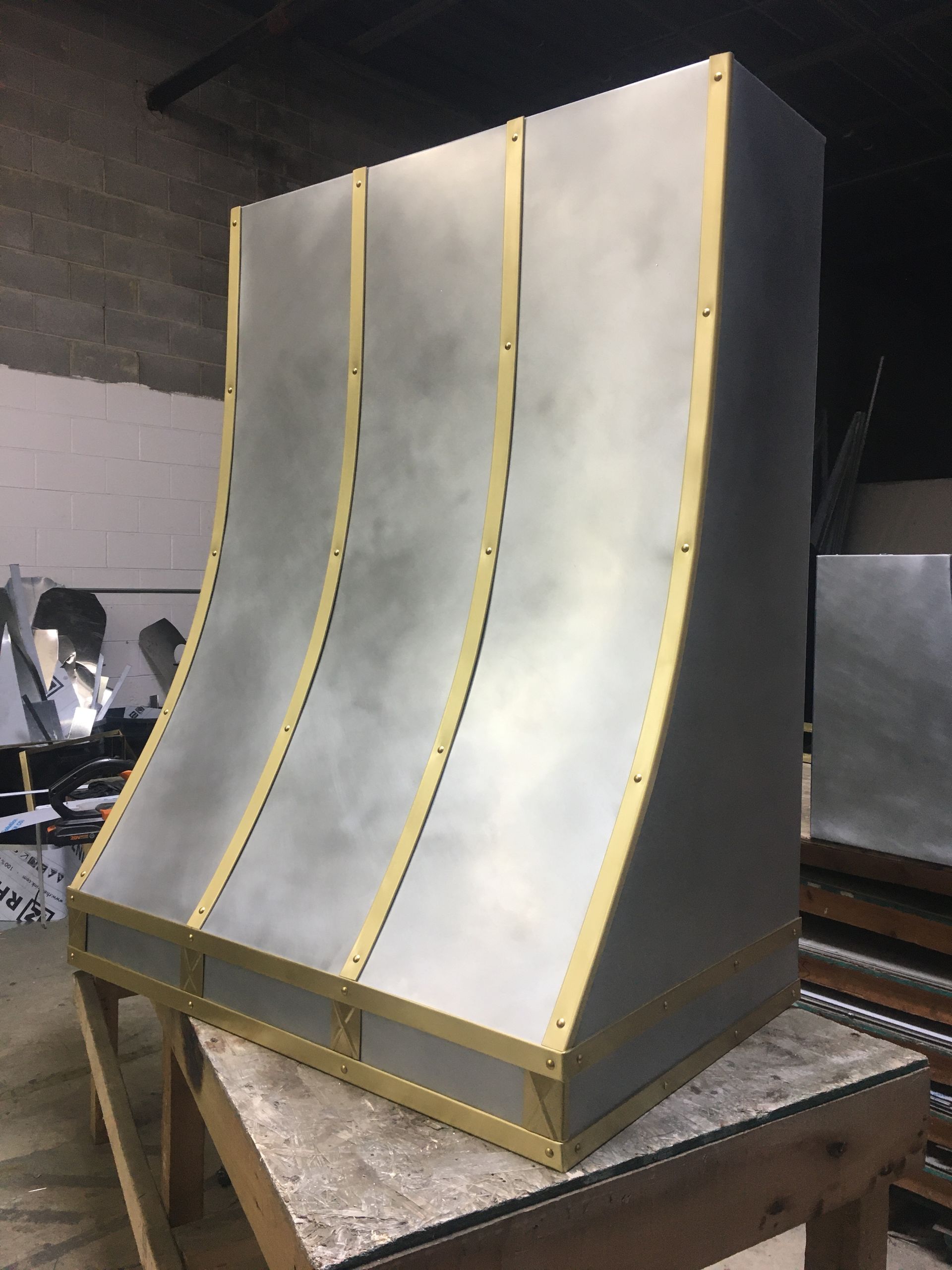 A stainless steel hood is sitting on top of a wooden table.