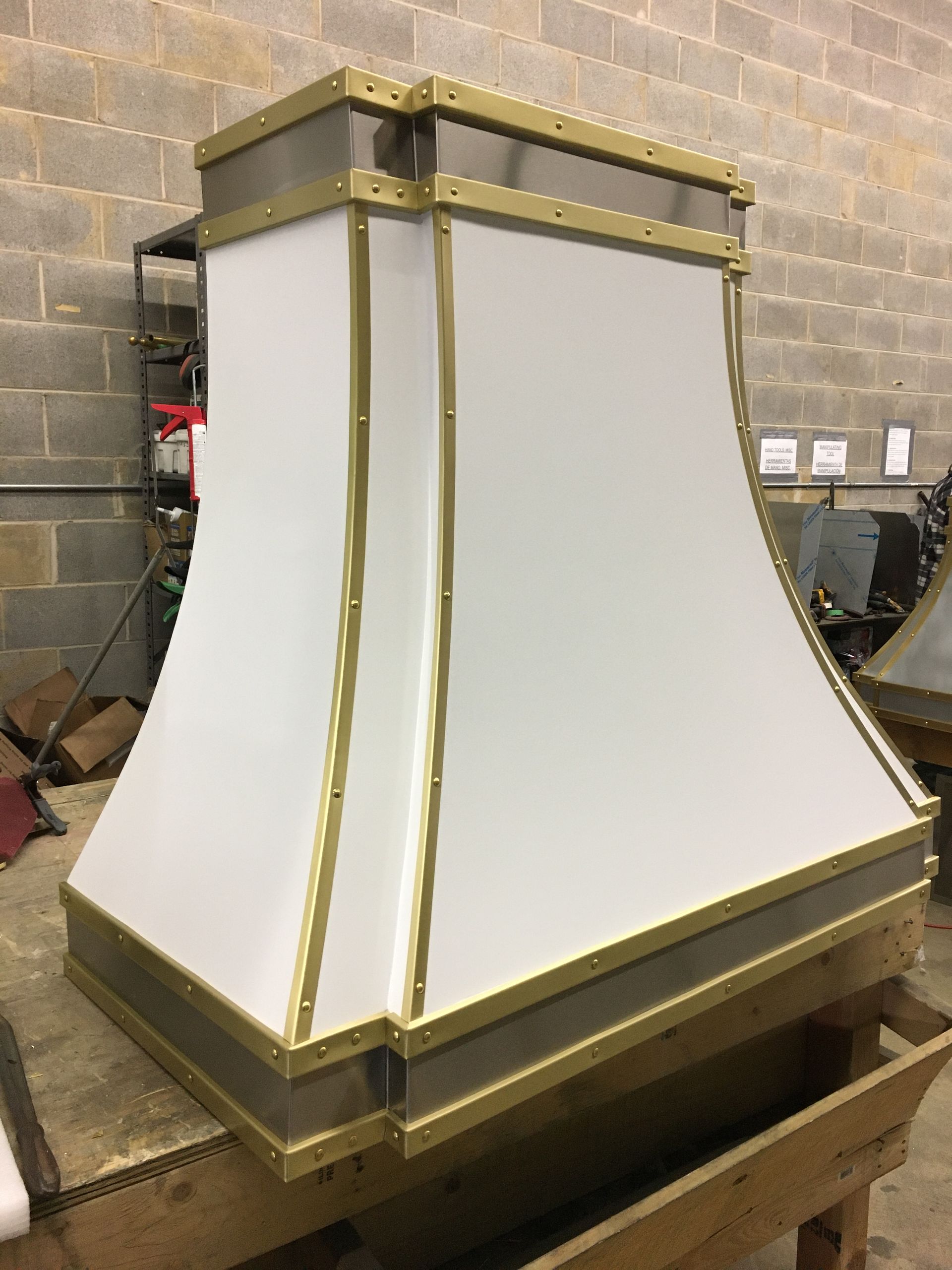 A white and gold hood is sitting on a wooden table.