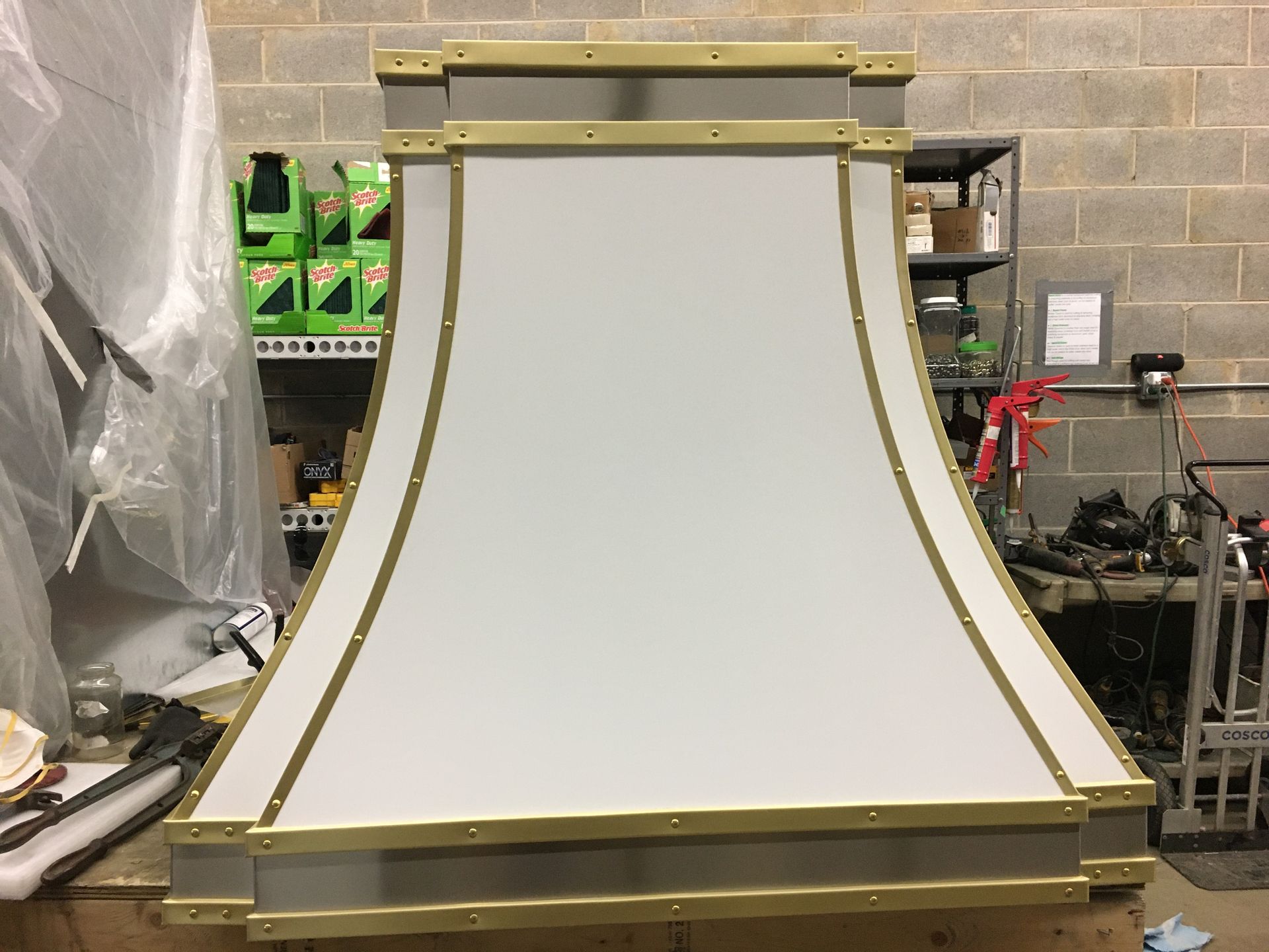 A white and gold hood is sitting on a table in a room.