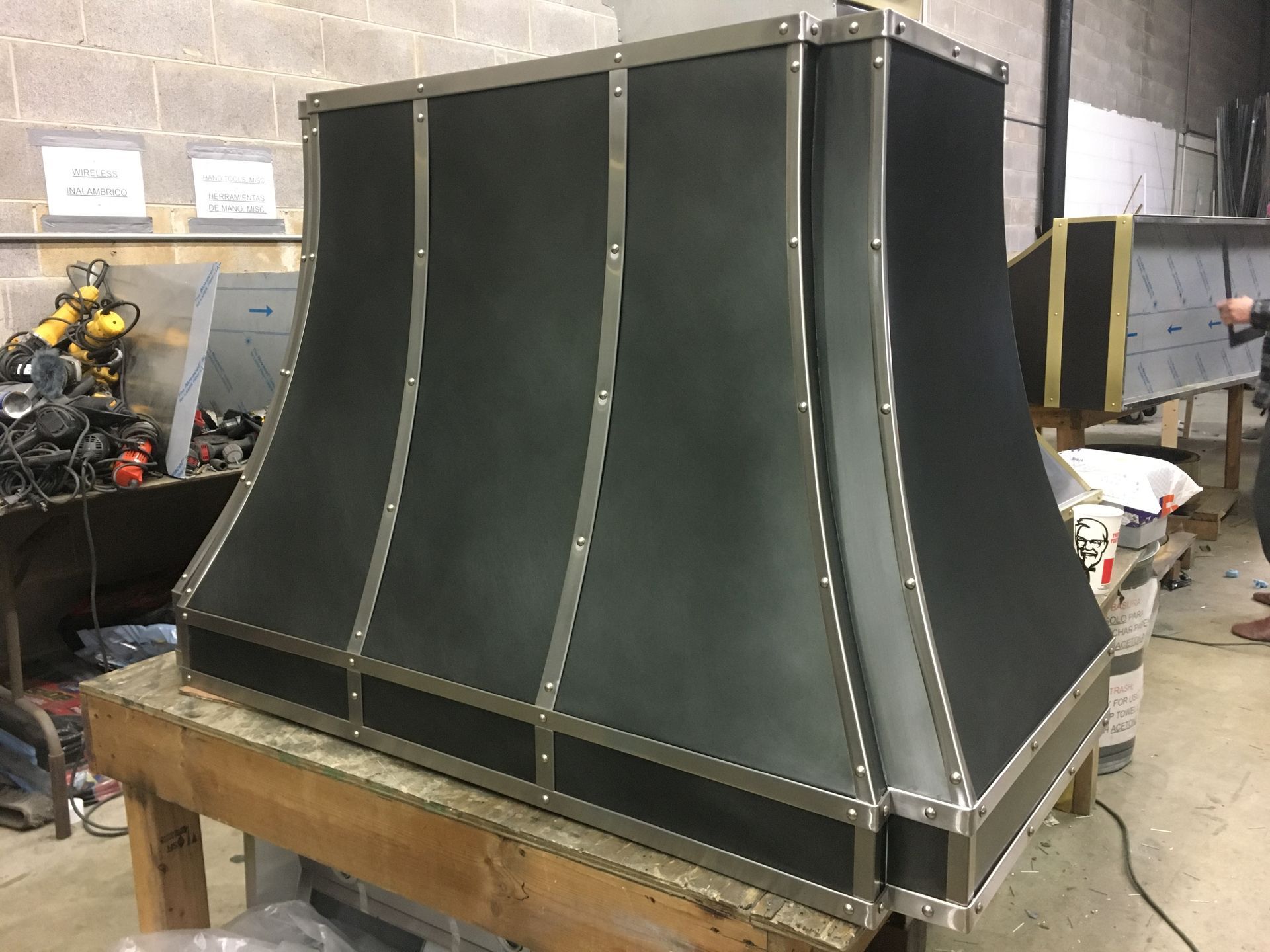 A black metal hood is sitting on top of a wooden table.