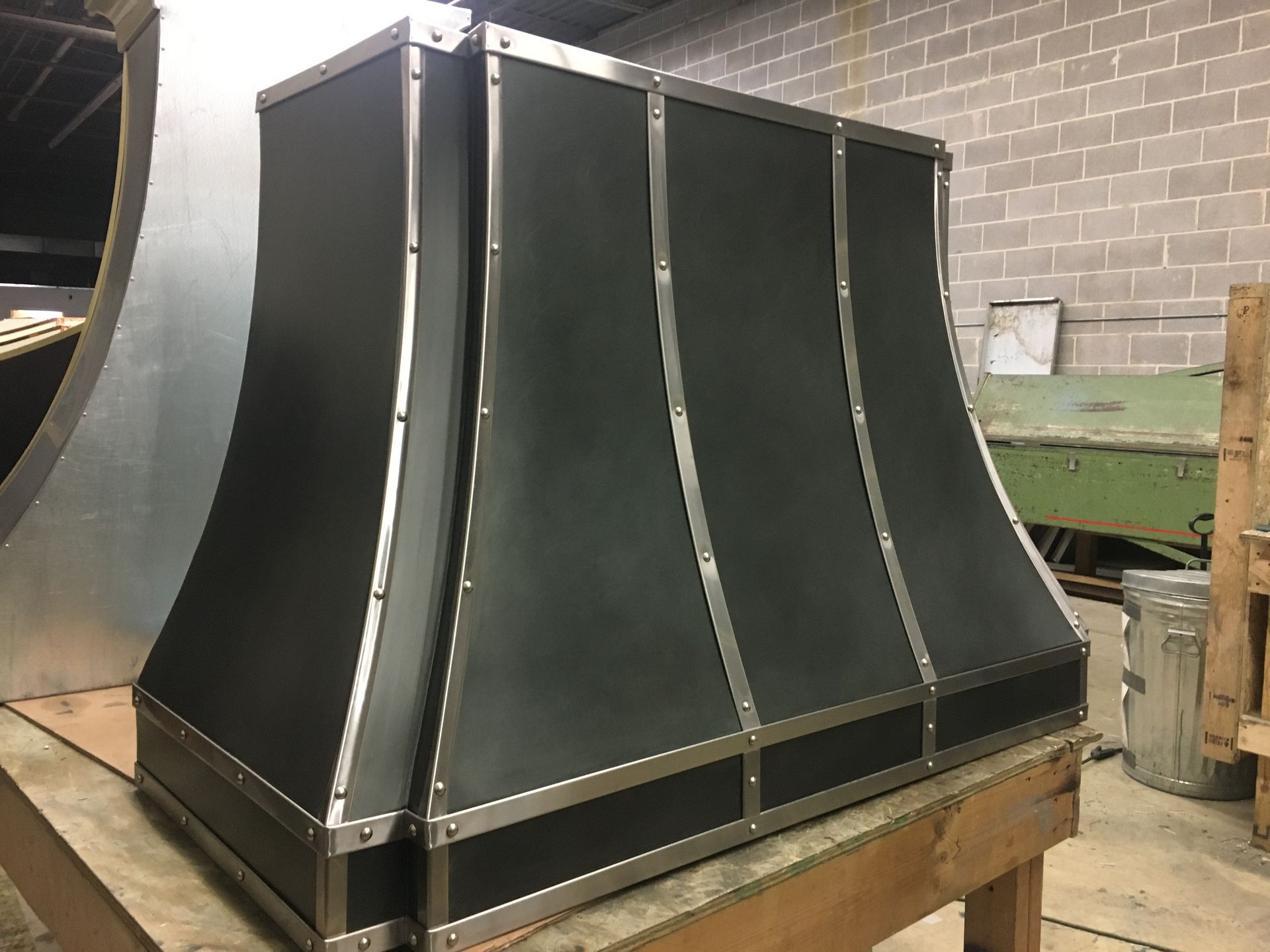 A black hood is sitting on top of a wooden table.