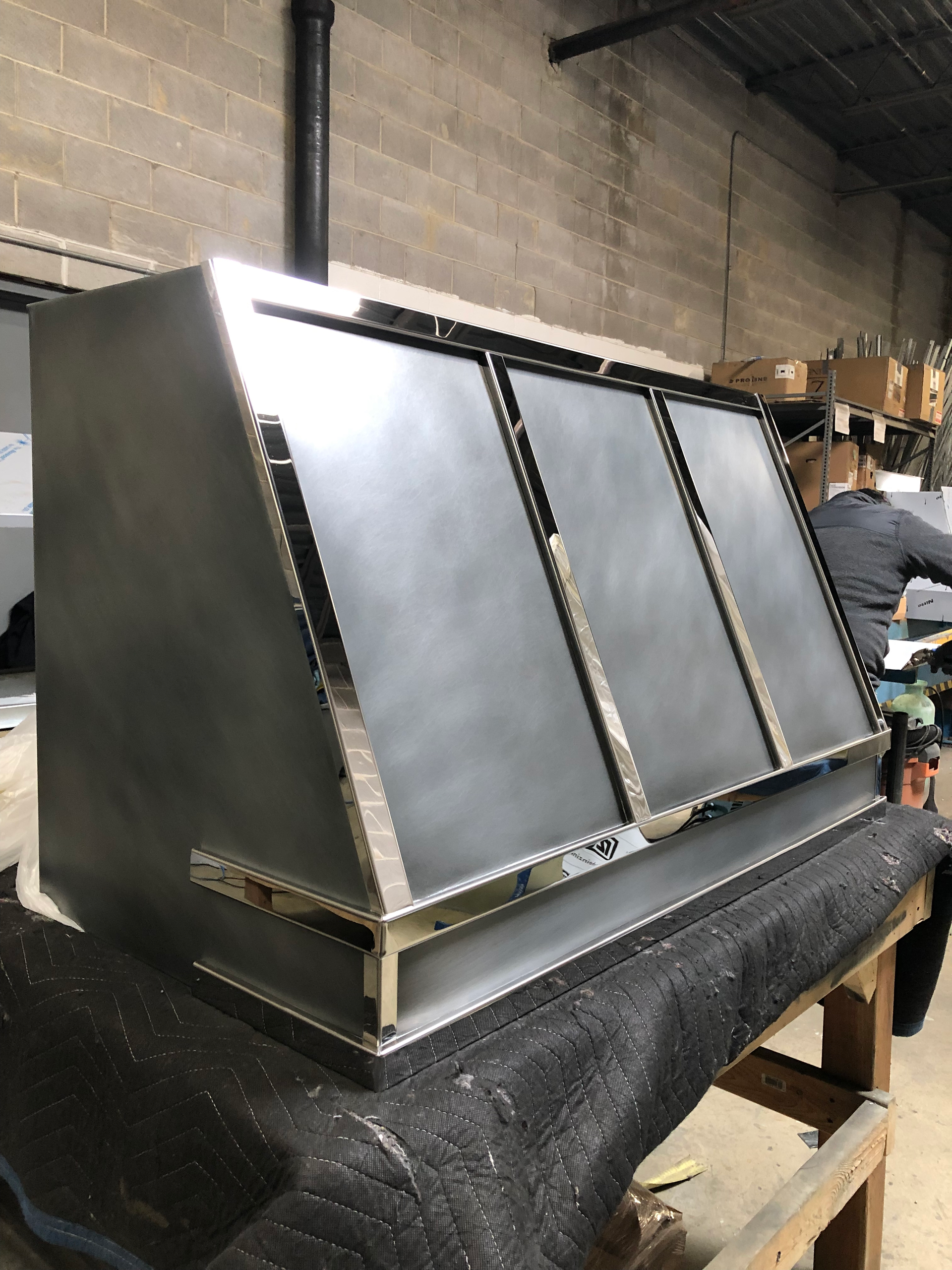 A stainless steel box is sitting on top of a wooden table.
