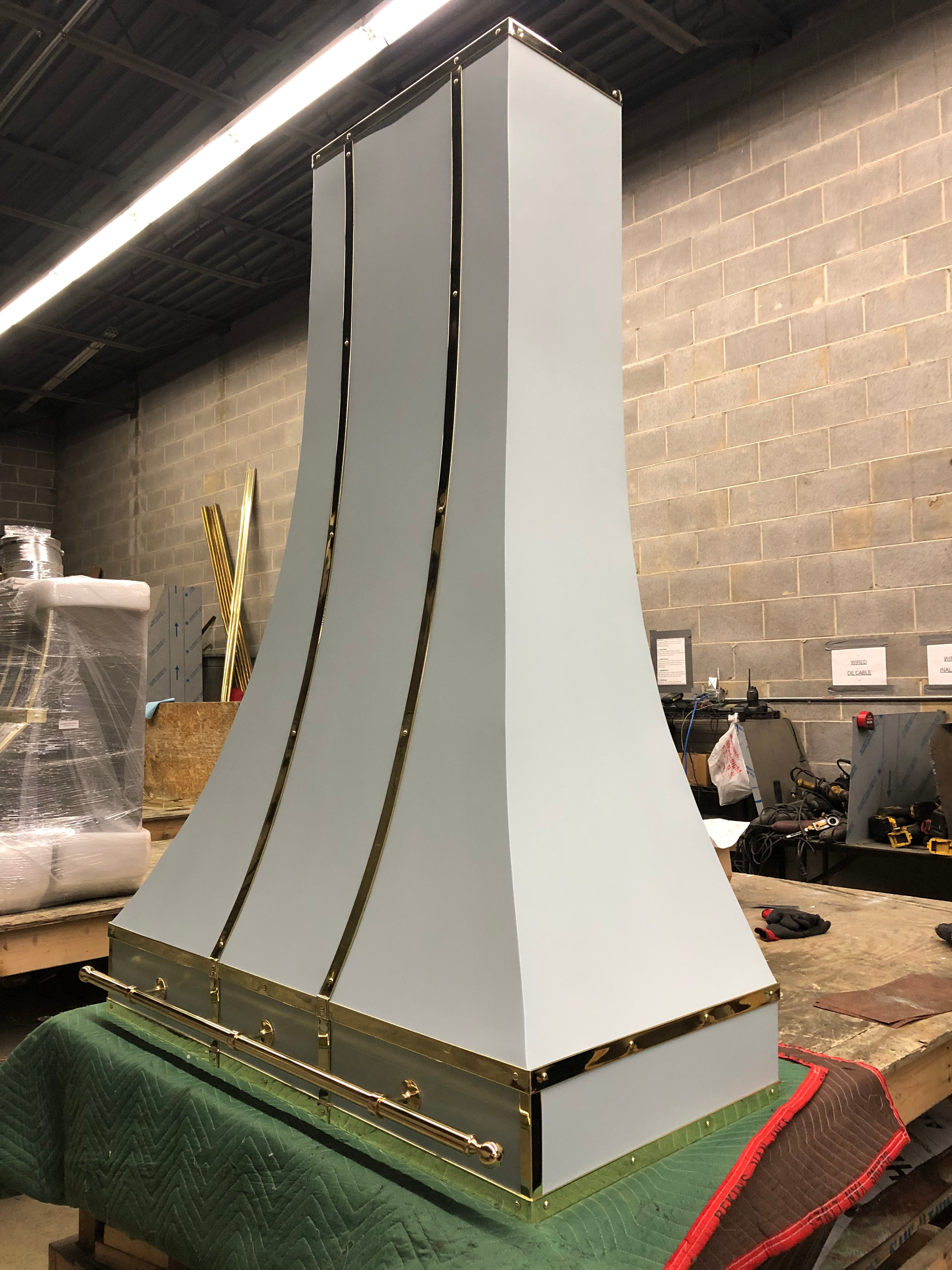 A white and gold hood is sitting on a table in a room.