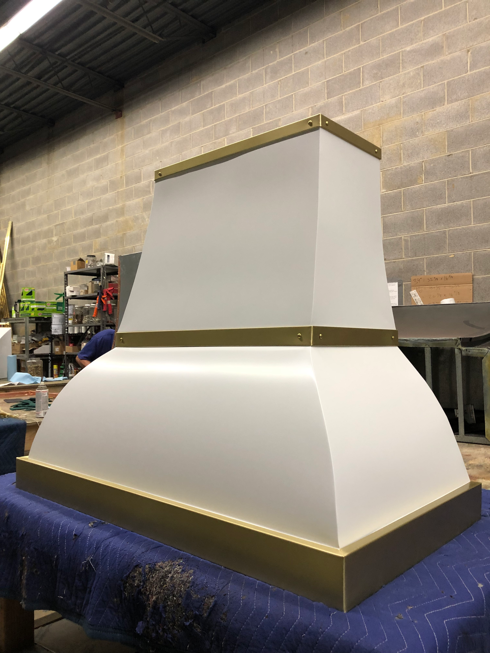 A white and gold hood is sitting on top of a blue table.