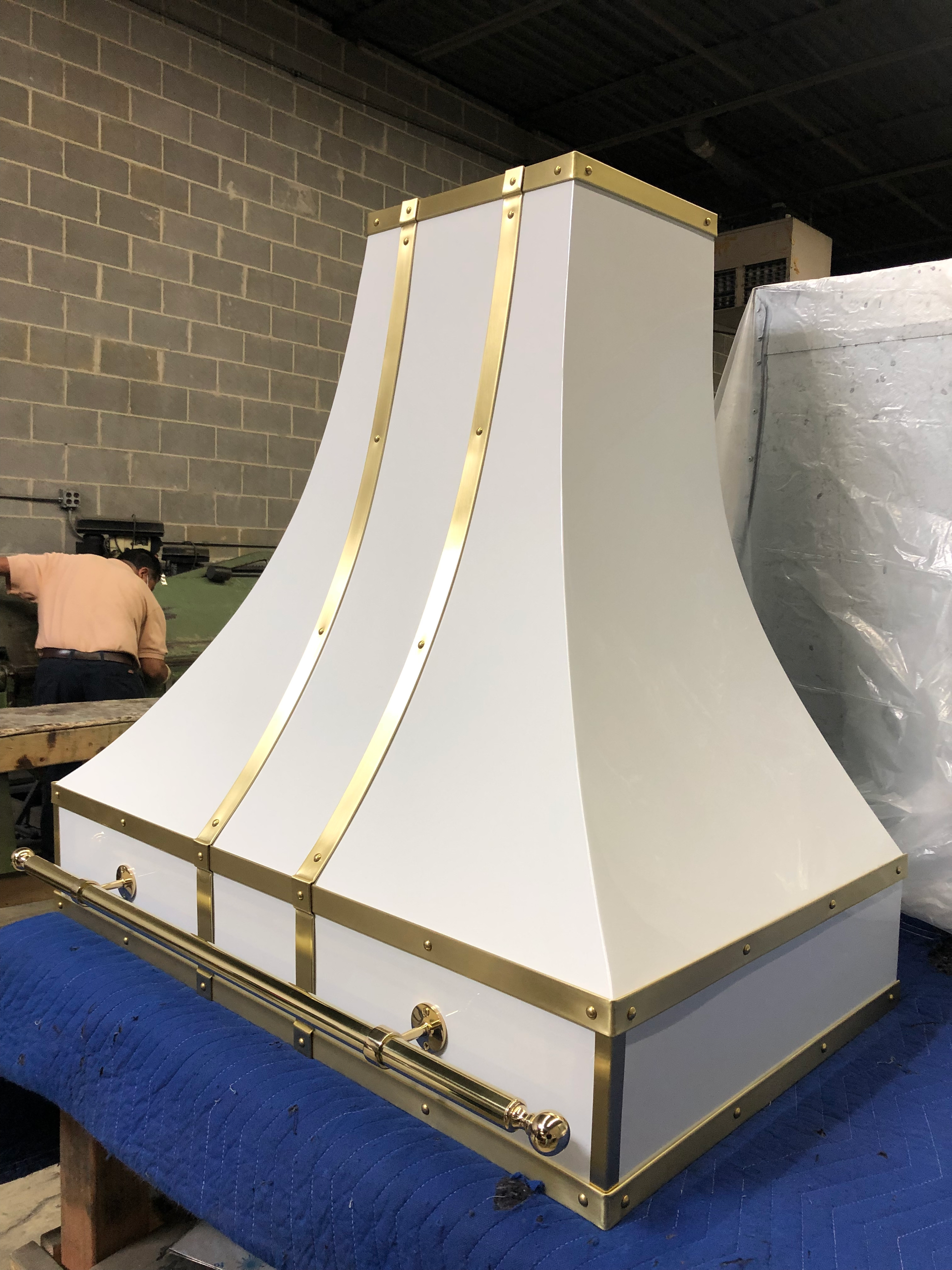 A white hood with gold trim is sitting on a blue table.