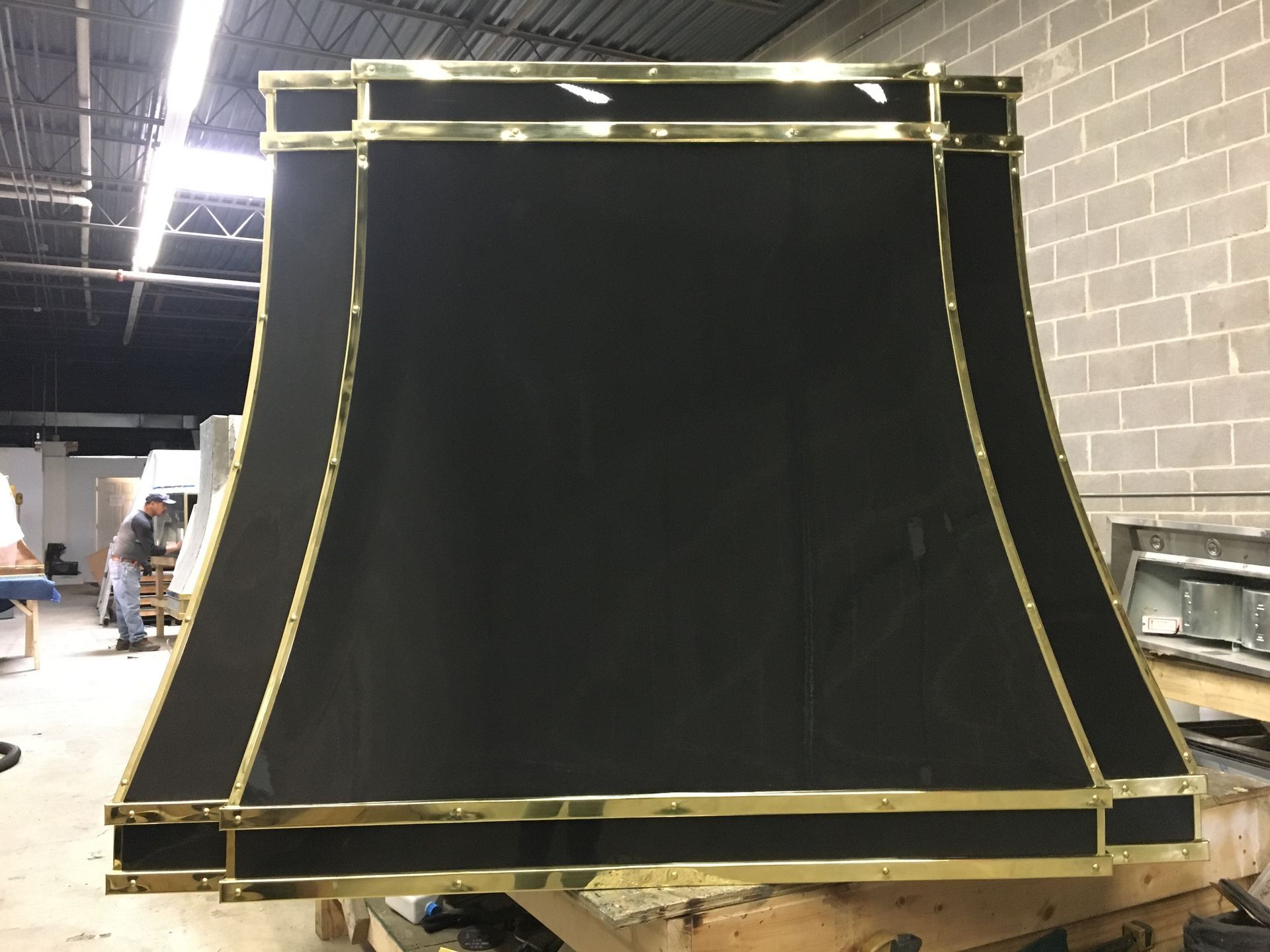 A black and gold lampshade is sitting on a wooden table
