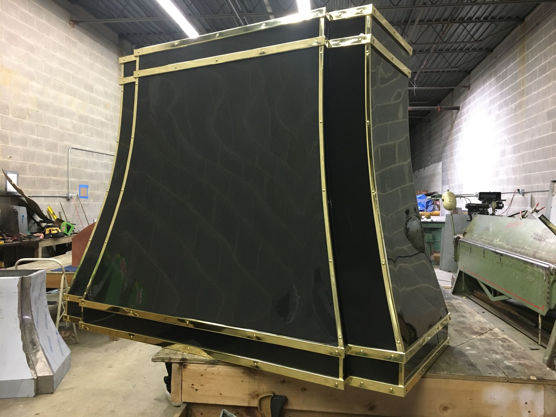 A black and gold lampshade is sitting on a wooden table in a room.