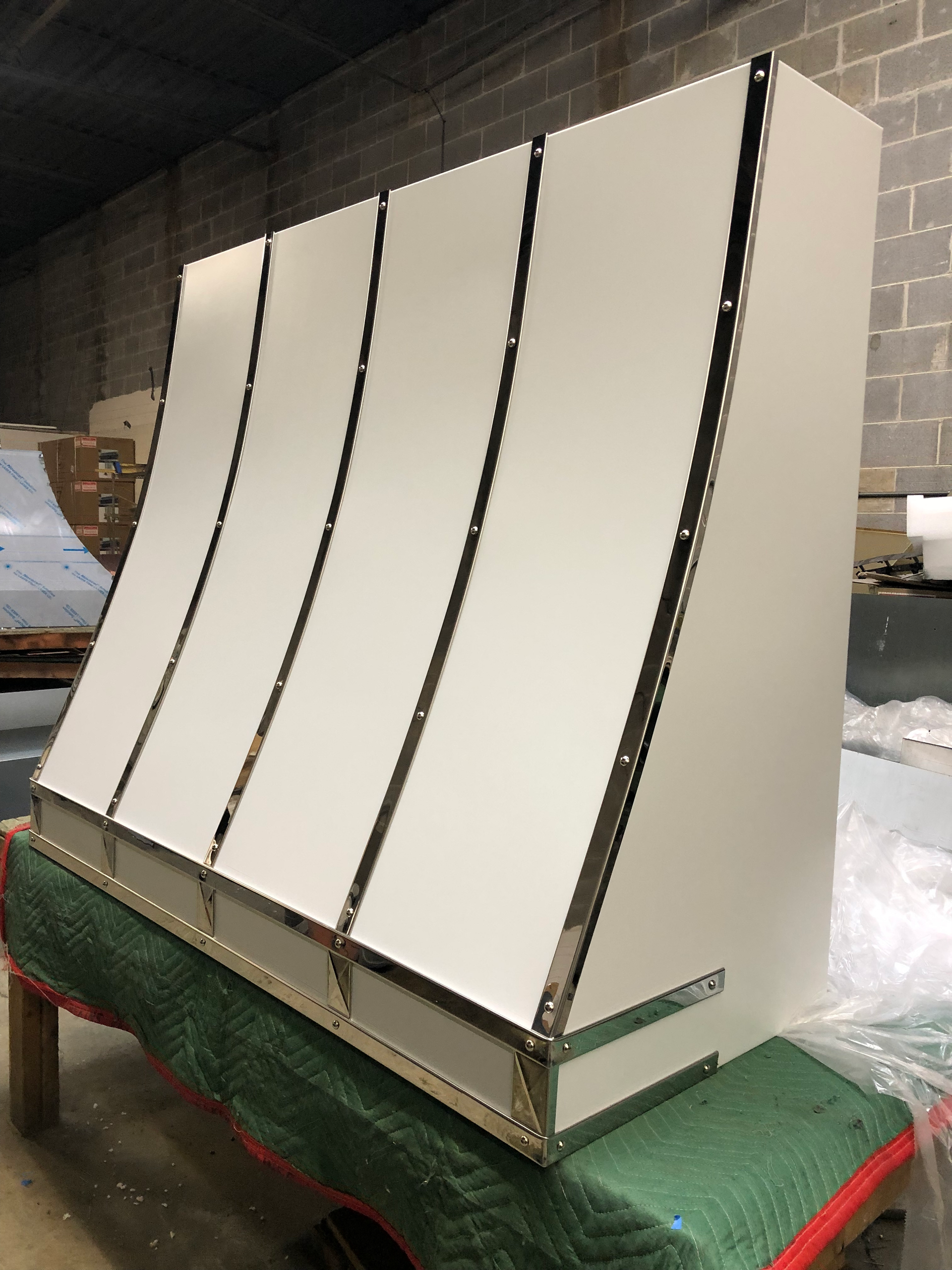 A white cabinet is sitting on top of a green table.