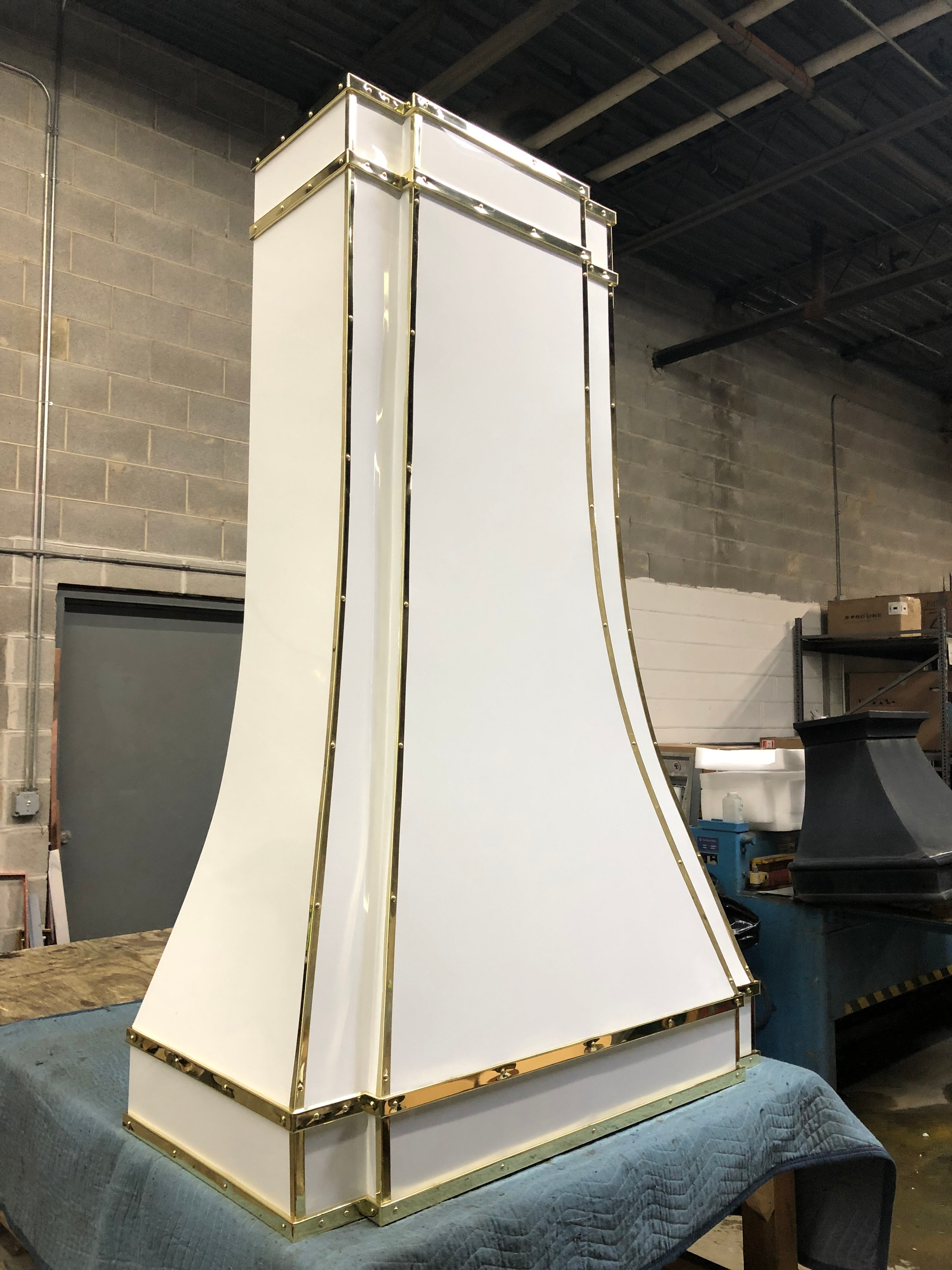 A white chimney with gold trim sits on a table