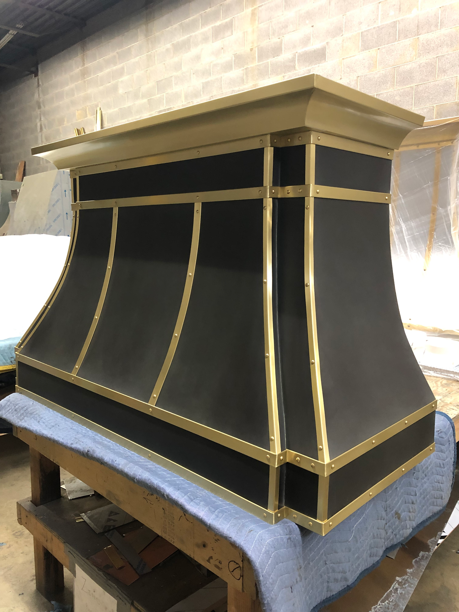 A black and gold hood is sitting on top of a wooden table.