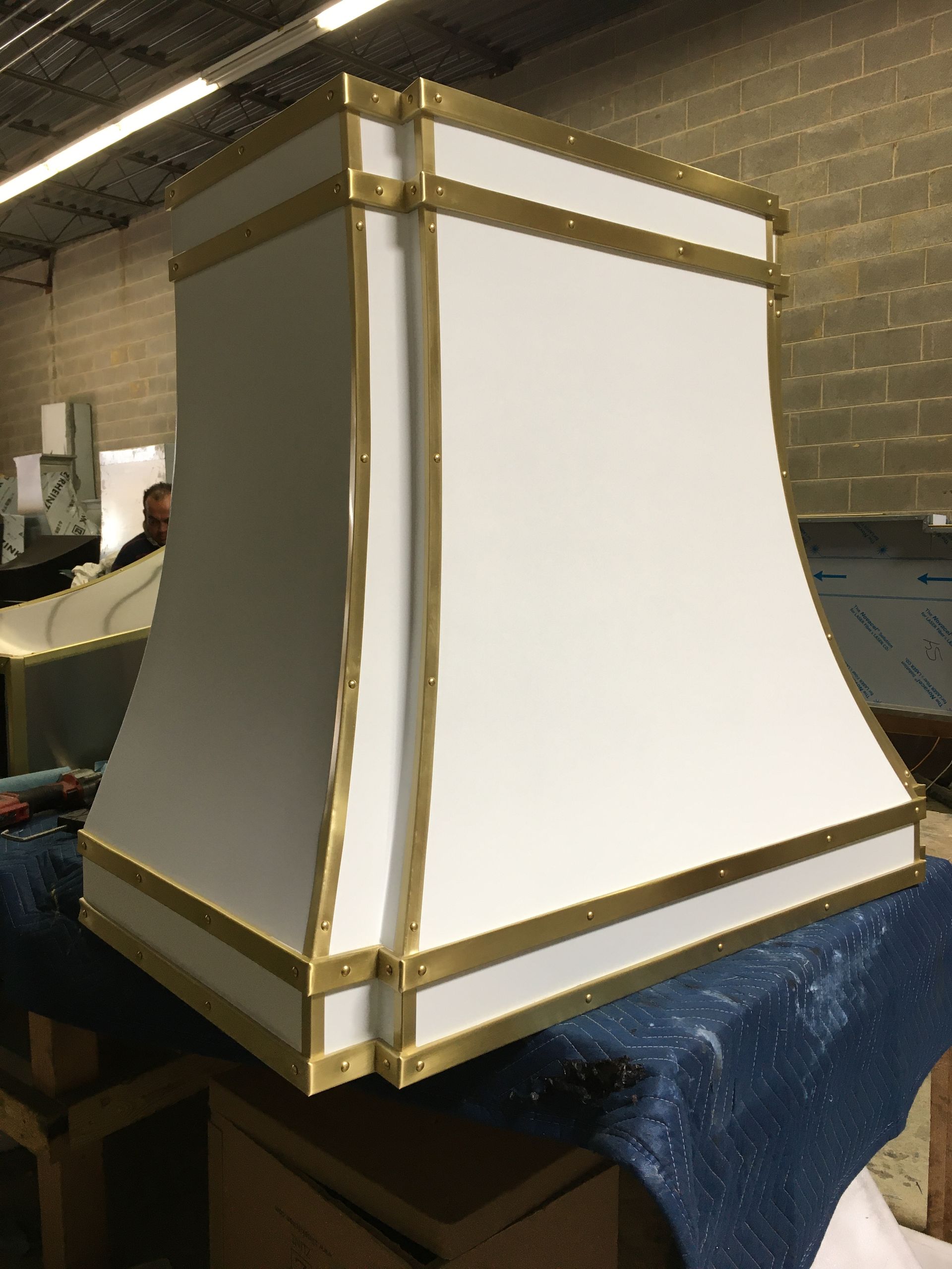 A white lampshade with gold trim is sitting on a table