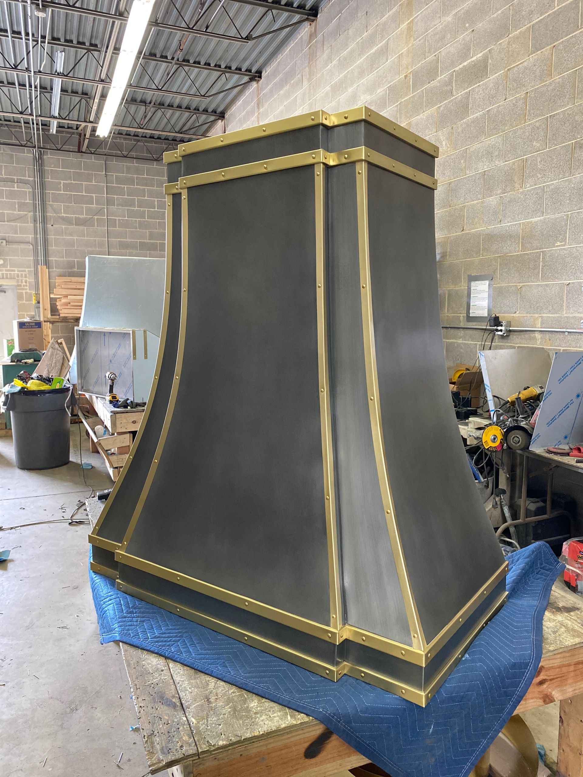 A black and gold hood is sitting on a table in a room.