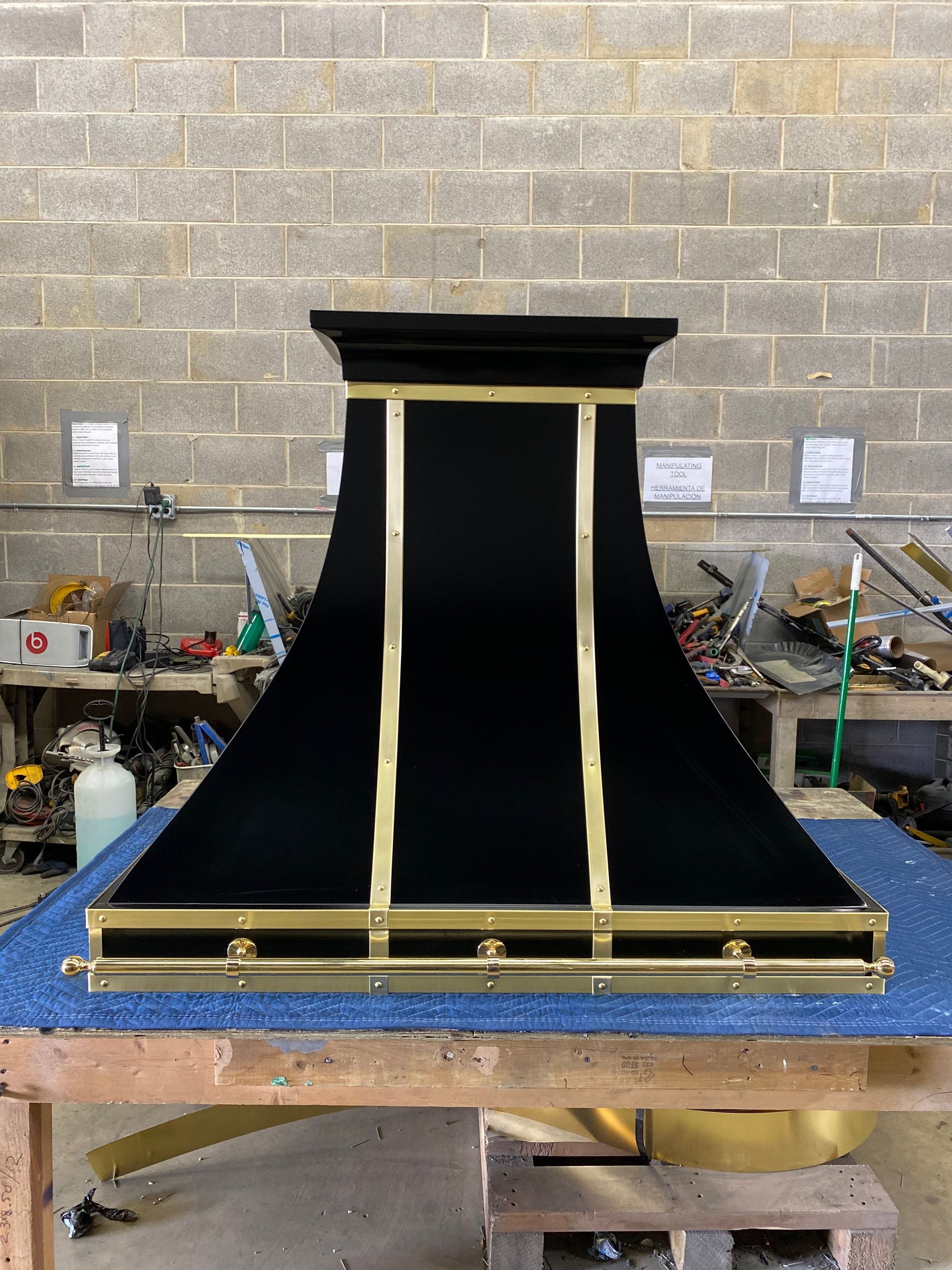 A black and gold hood is sitting on top of a blue table.