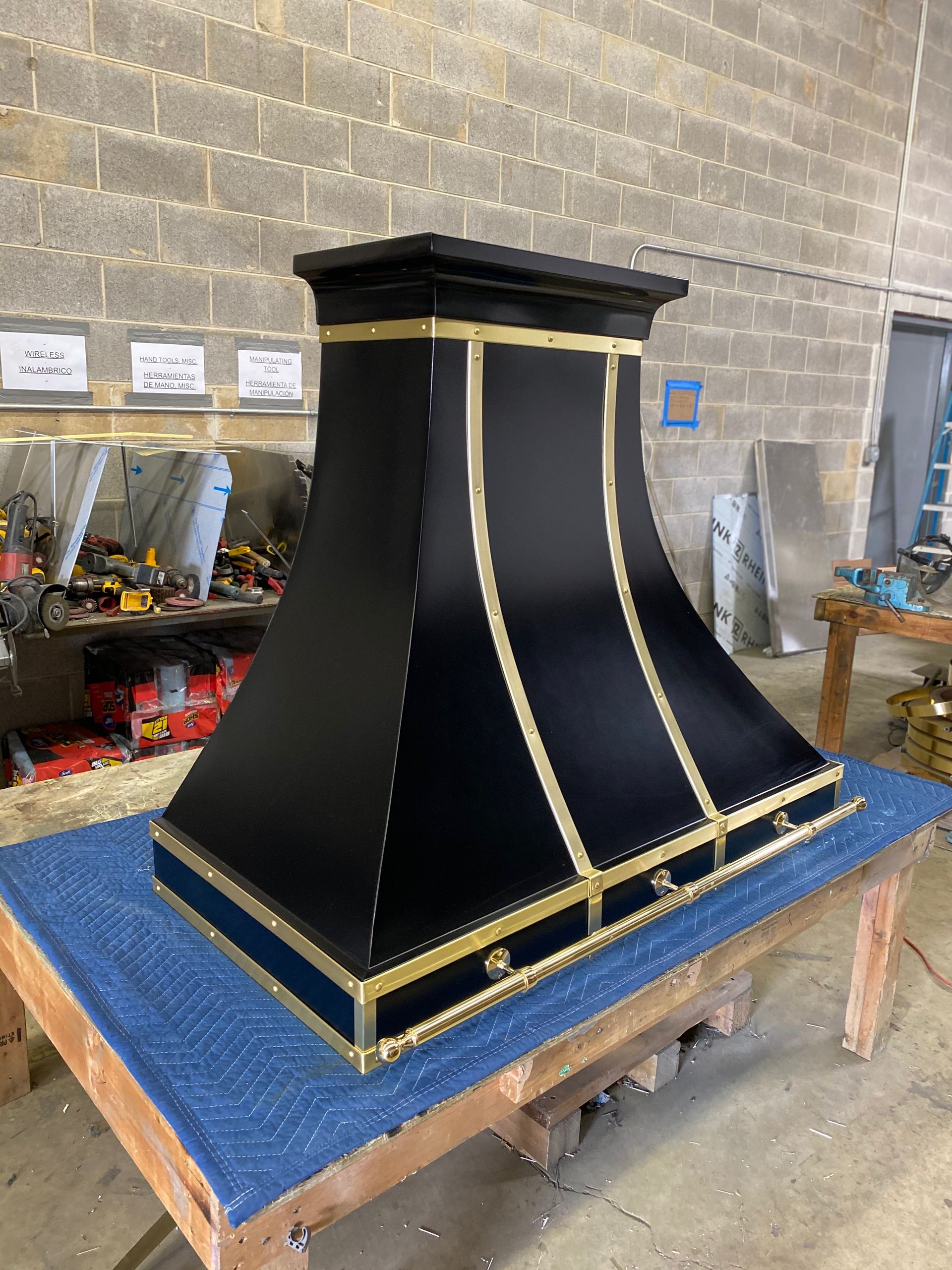 A black and gold hood is sitting on top of a wooden table.