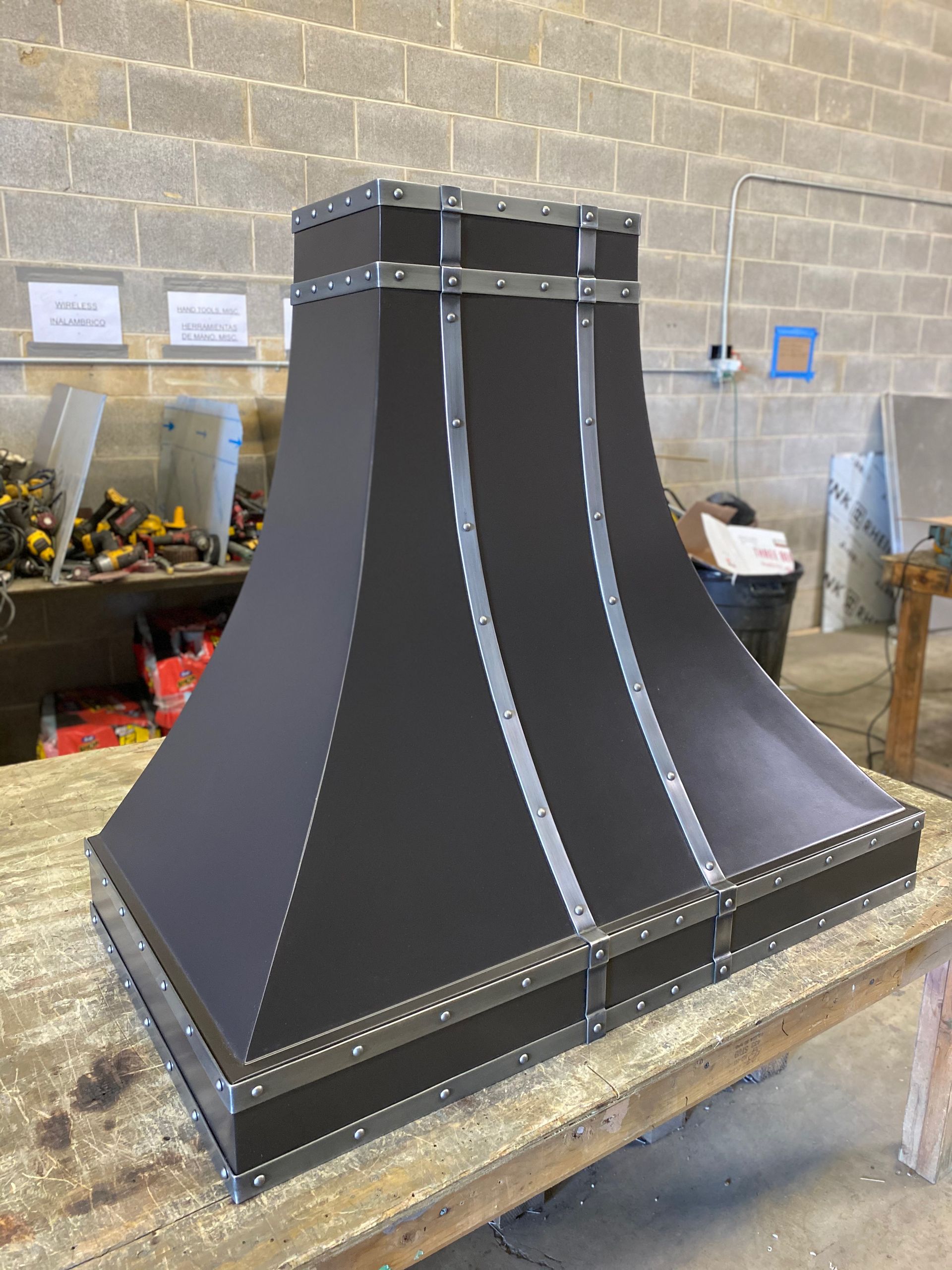 A black hood is sitting on top of a wooden table.