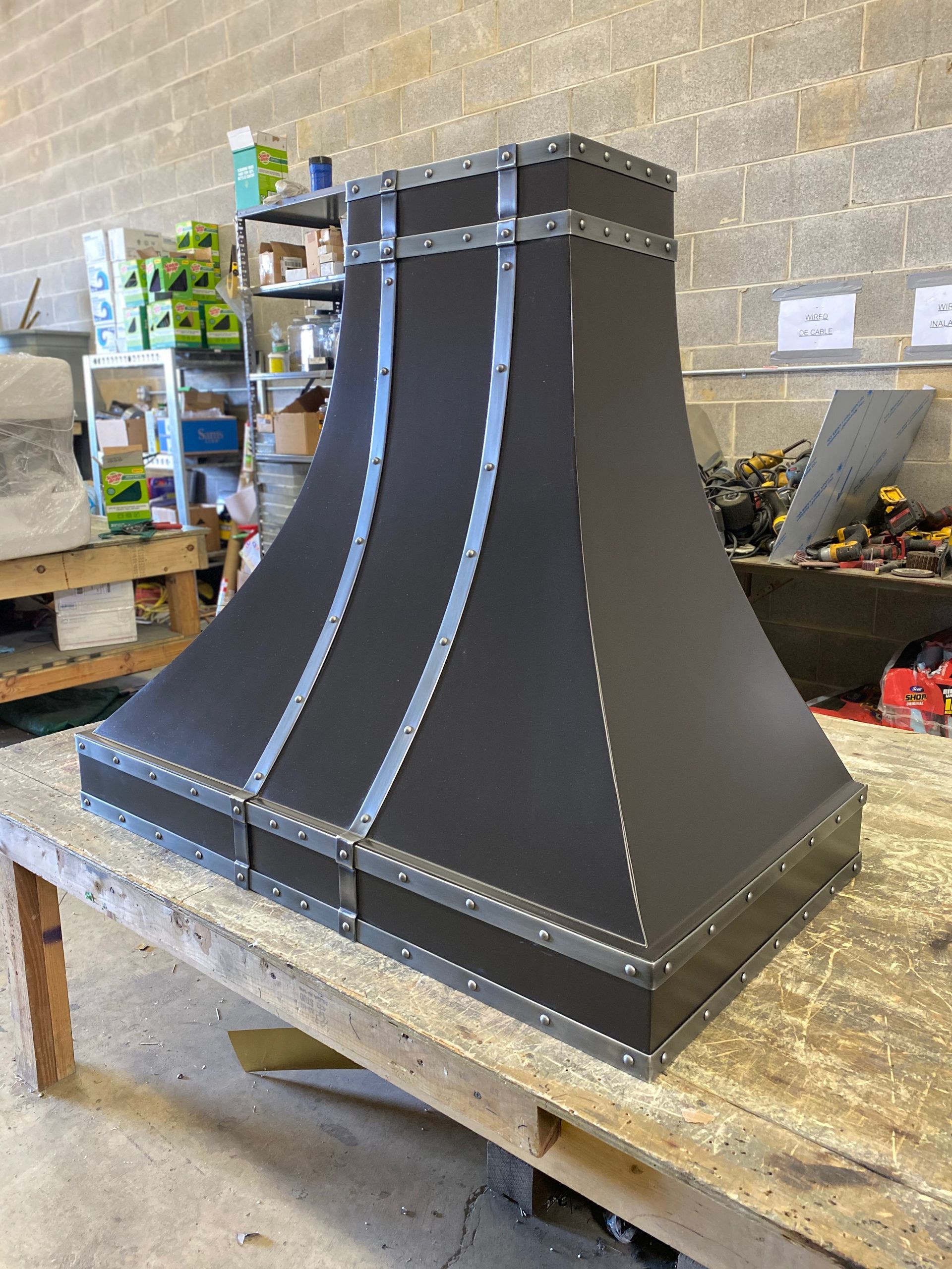 A black hood is sitting on top of a wooden table.