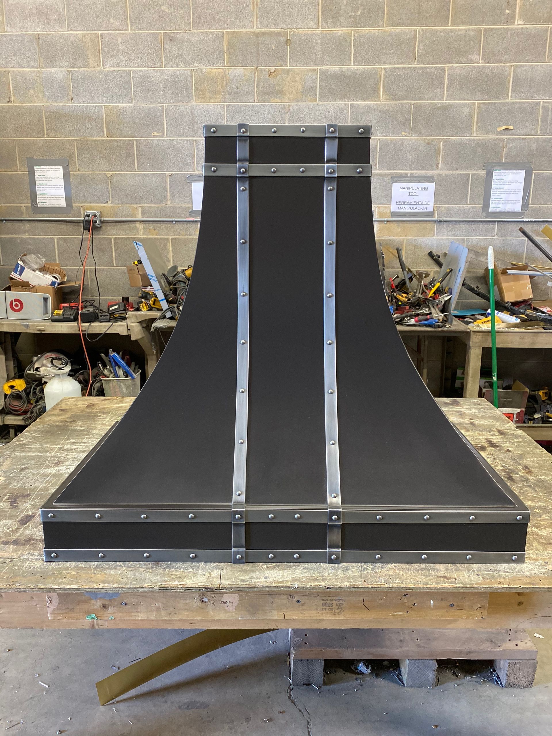 A black hood is sitting on top of a wooden table.