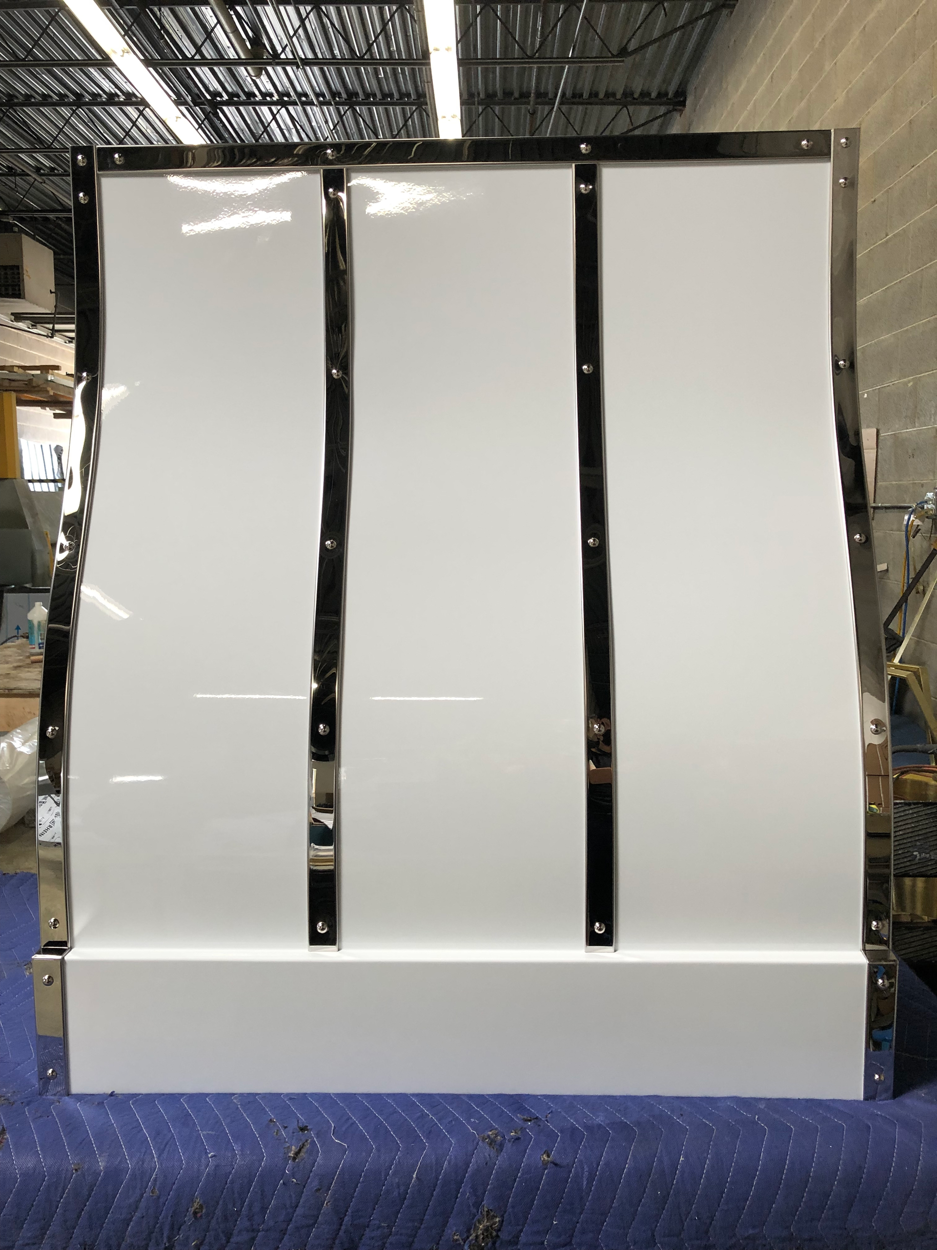 A white wall with black trim is sitting on a blue carpet.