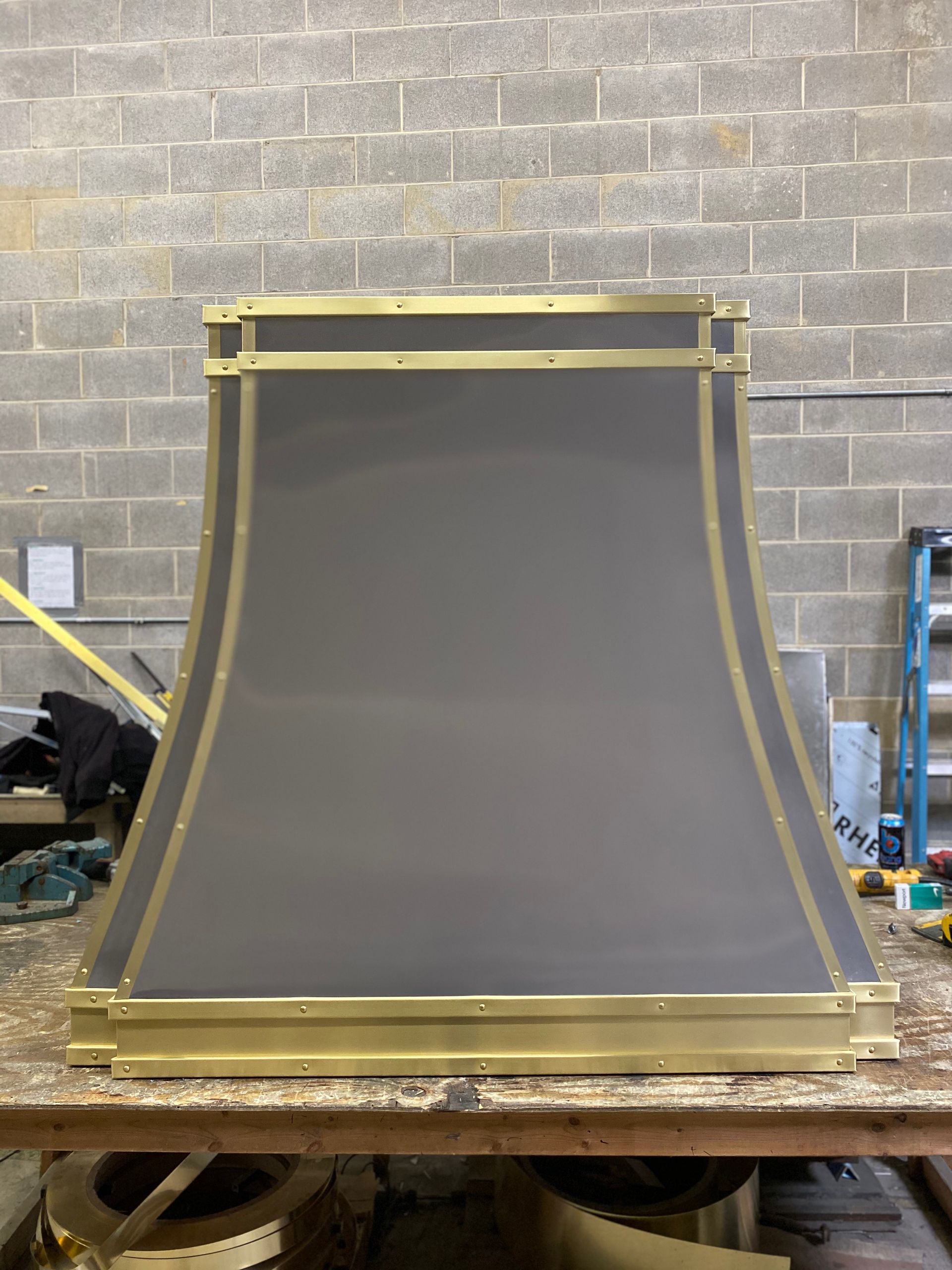 A lampshade is sitting on a wooden table in front of a brick wall.