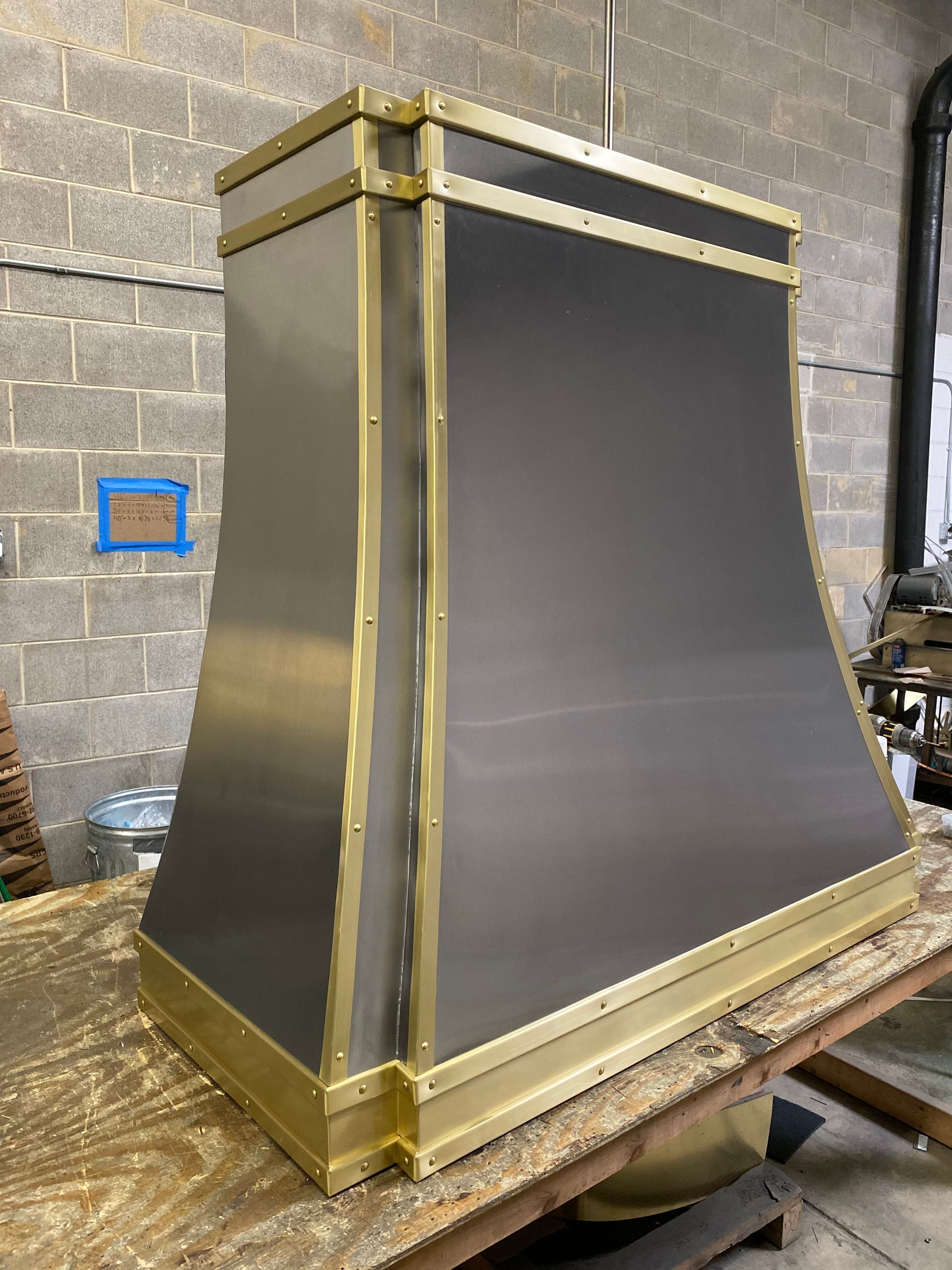 A black and gold hood is sitting on top of a wooden table.