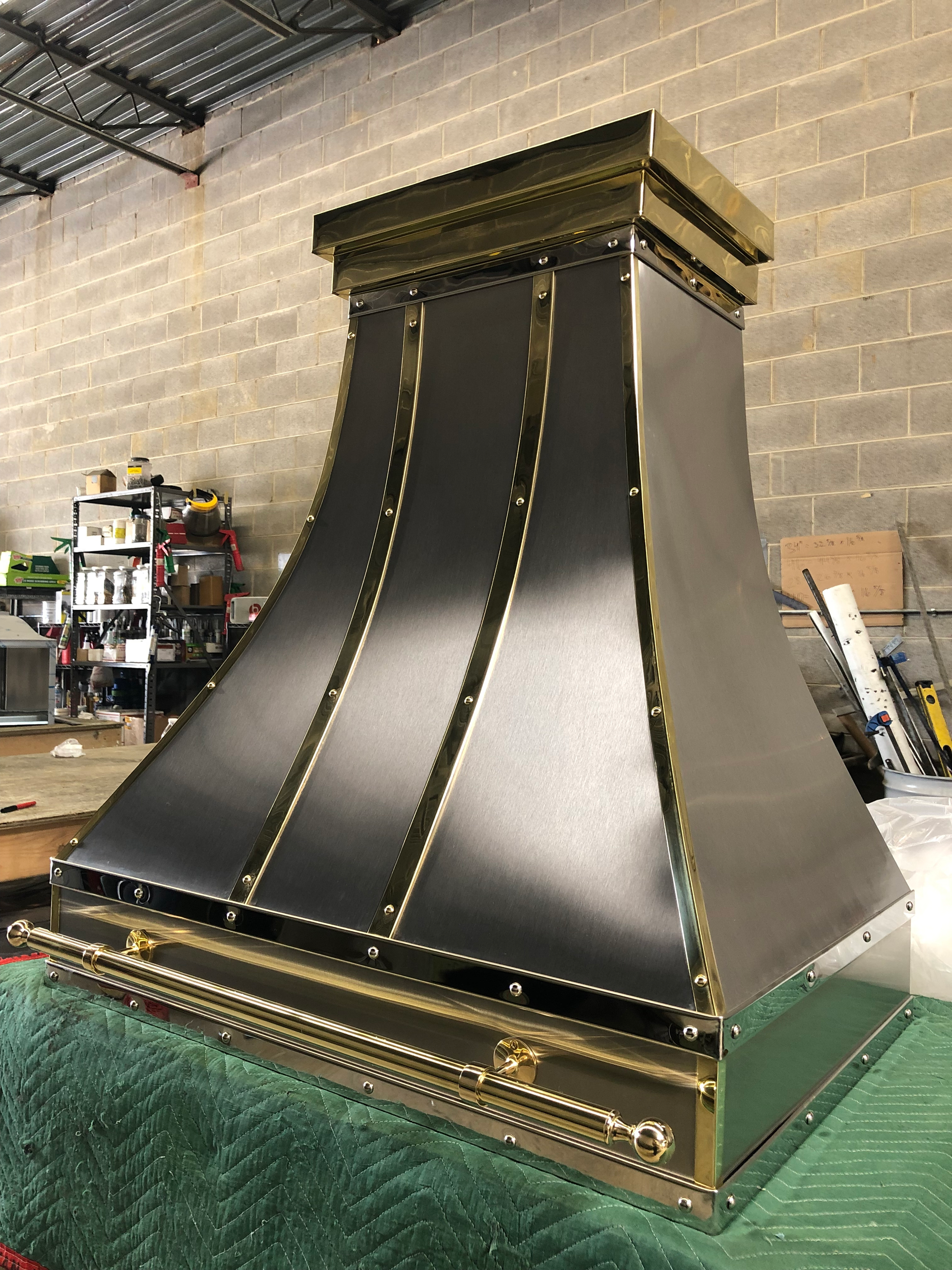 A black and gold hood is sitting on a green carpet in a room.
