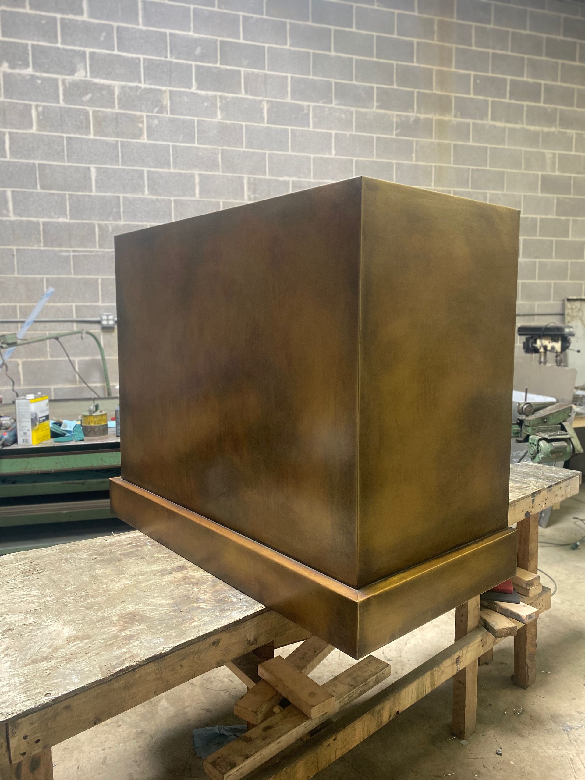 A large brass cube is sitting on top of a wooden table.