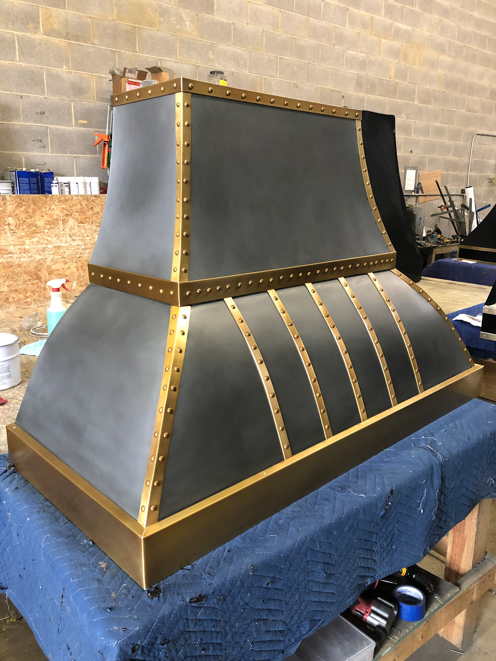 A black and gold hood is sitting on a blue table.