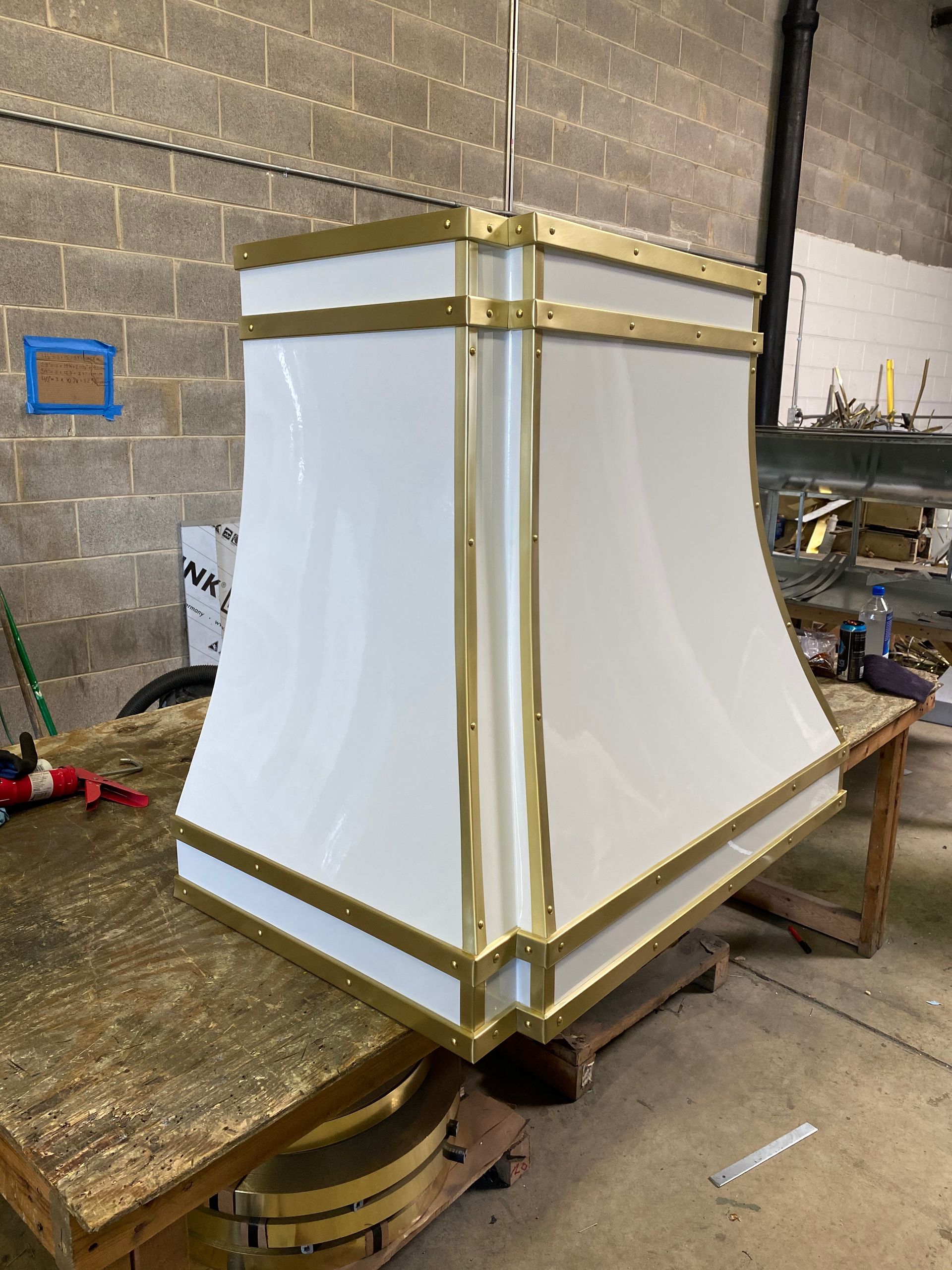 A white and gold hood is sitting on top of a wooden table.