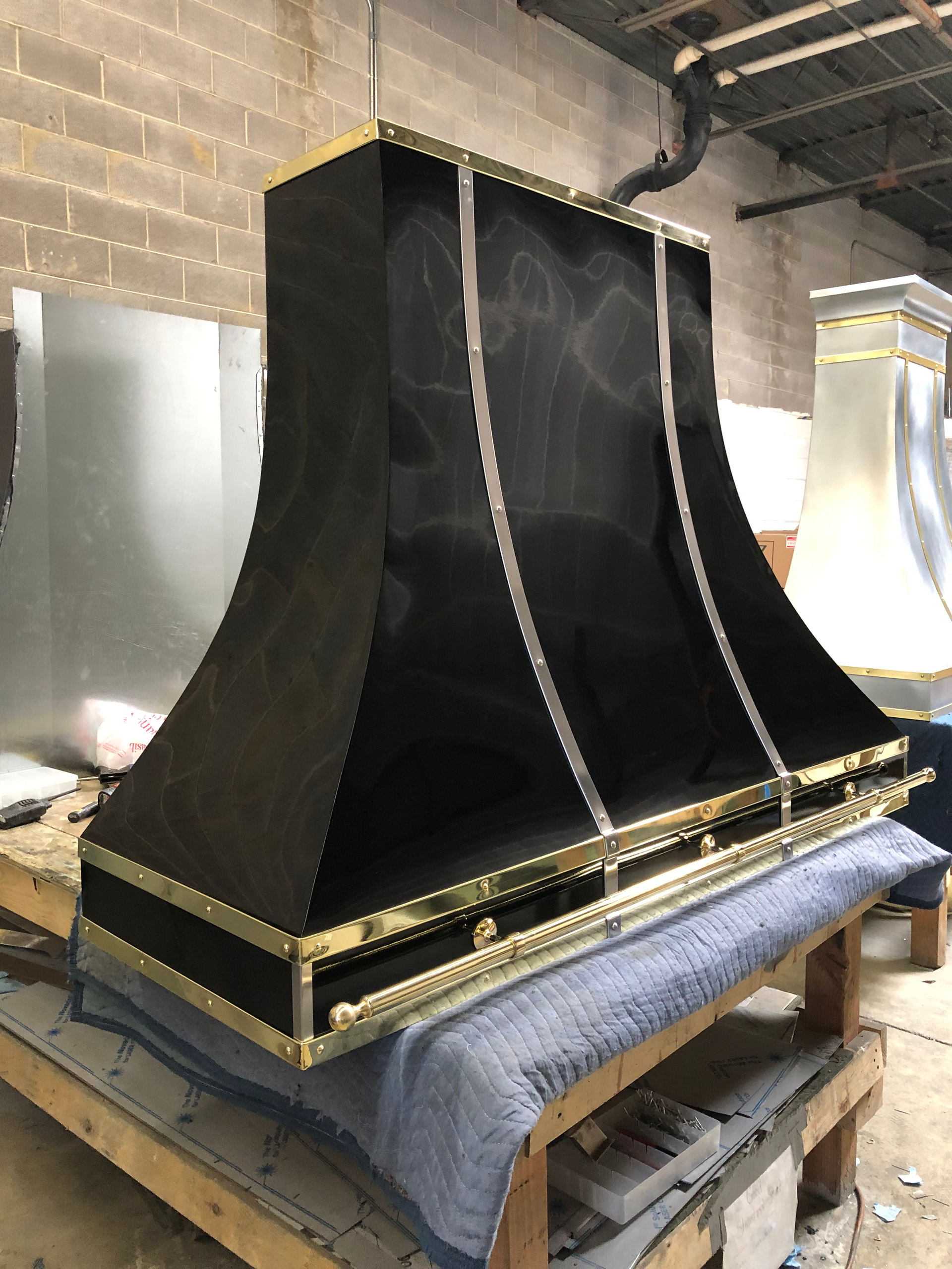 A black and gold hood is sitting on top of a wooden table.