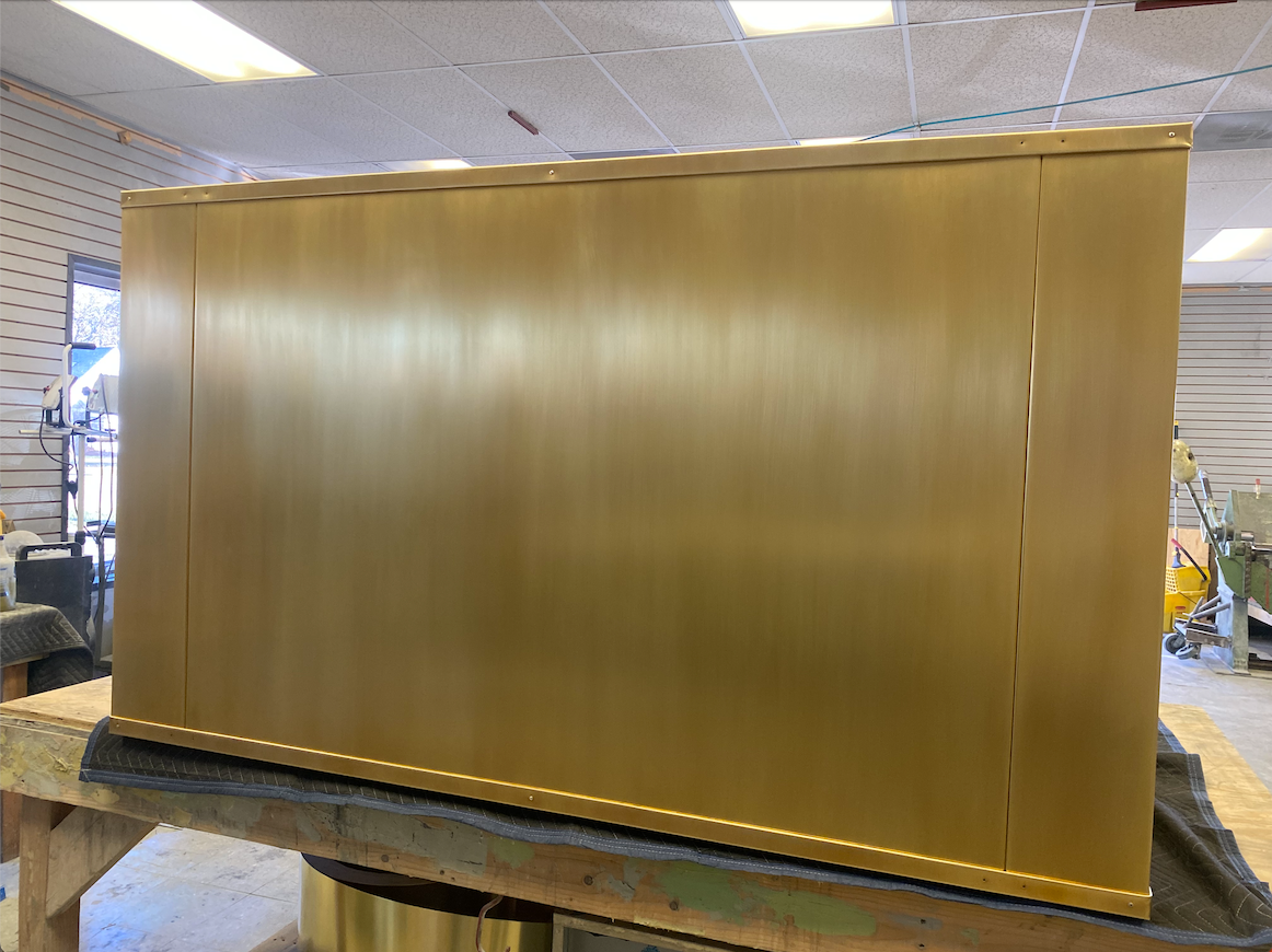 A large gold box is sitting on top of a wooden table.